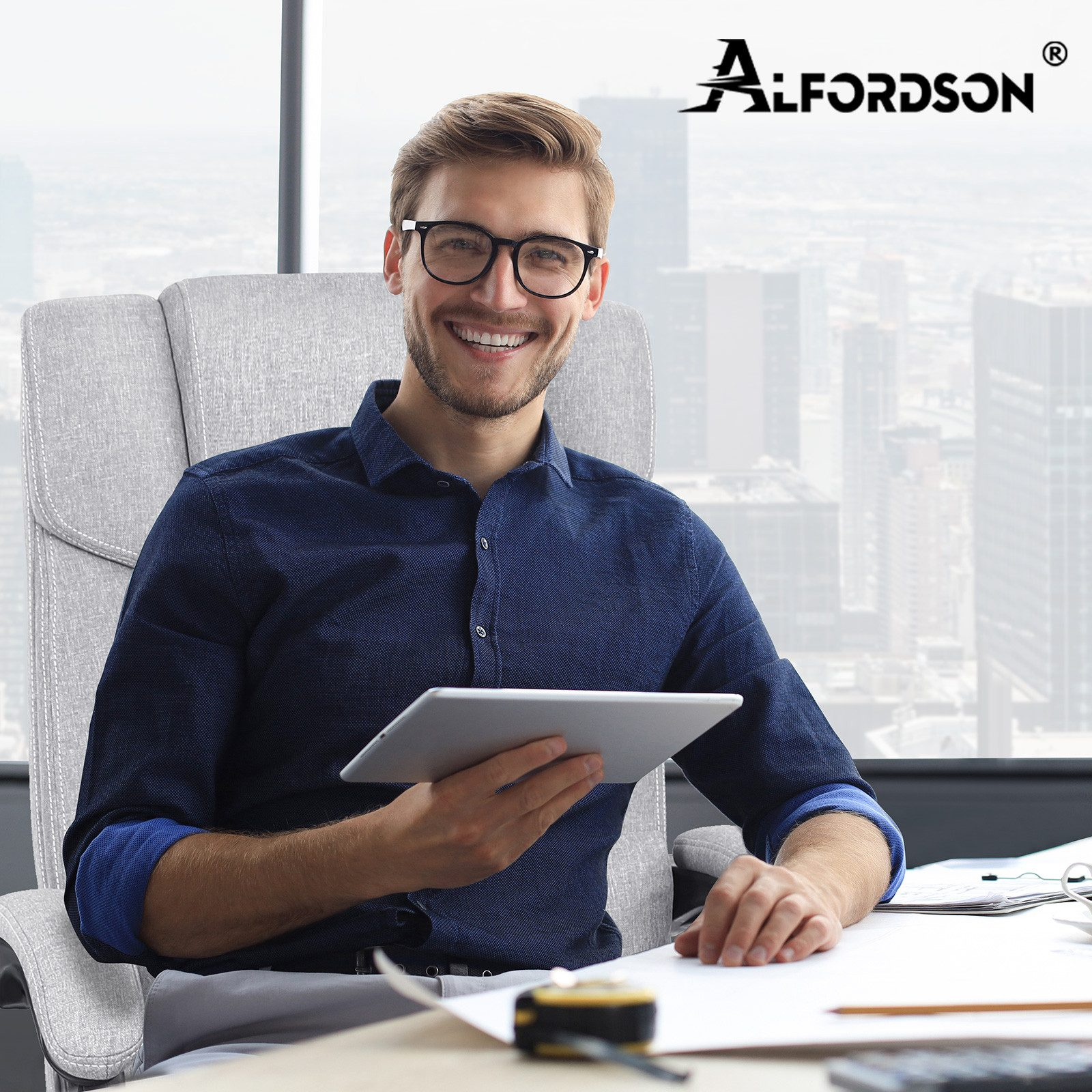 Mann mit Brille lächelt und hält ein Tablet. Er sitzt in einem Bürostuhl, in der Nähe eines Fensters mit Stadtblick. Alfordson-Logo.