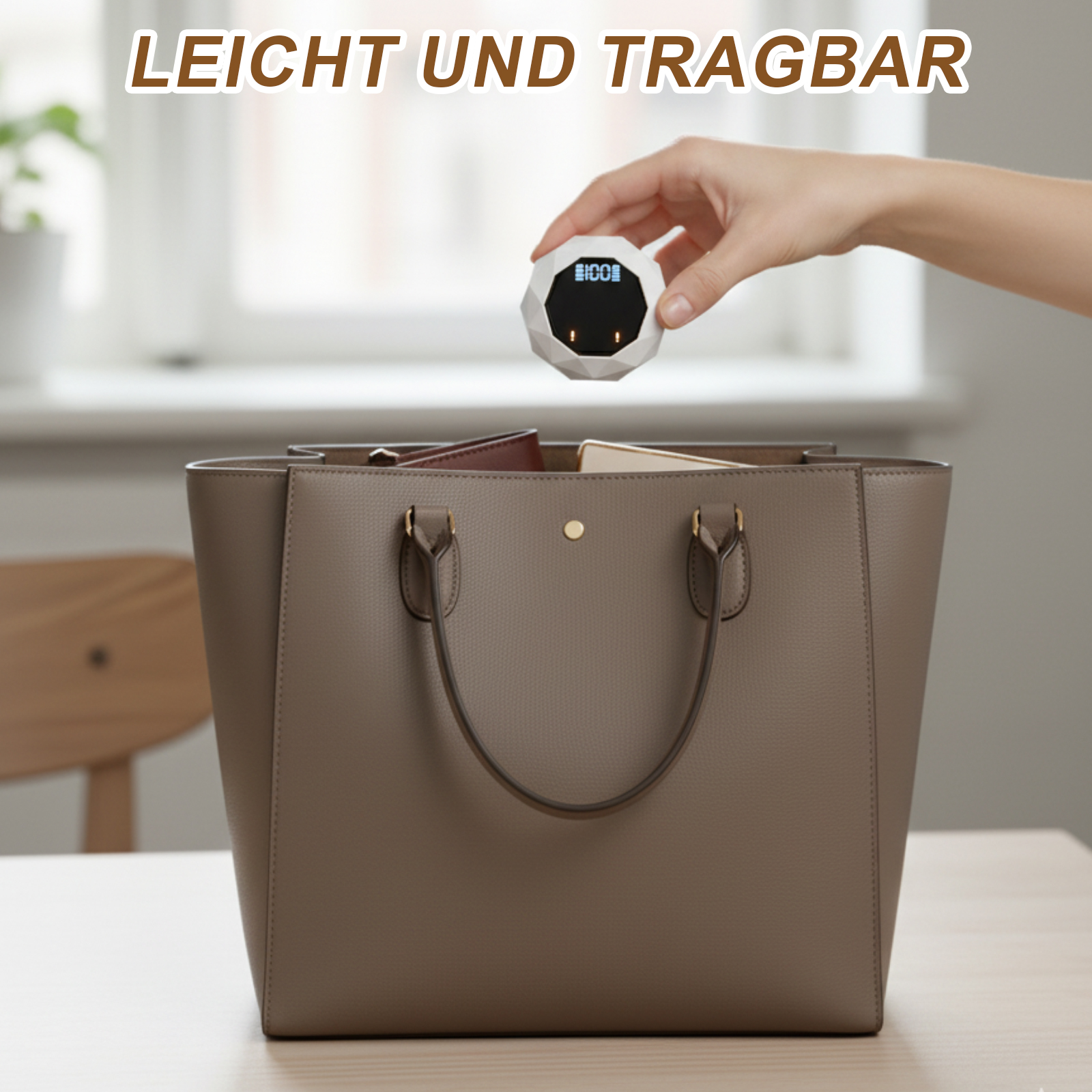 Eine Hand hält ein weißes, geometrisches Gerät über einer grauen Handtasche auf einem Tisch. Der Text 'LEICHT UND TRAGBAR' steht oben.