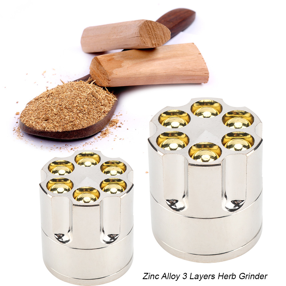 Zwei silberne Kräutermühlen, ein Holzlöffel mit Pulver und Holzstäbchen auf weißem Hintergrund.