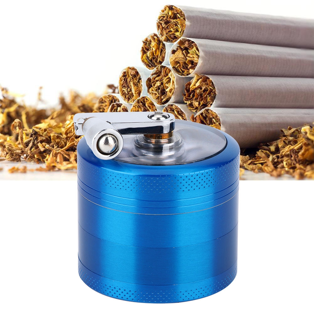 Ein blauer Grinder mit silbernem Griff. Zigaretten und Tabak sind im Hintergrund. Der Grinder ist im Vordergrund.