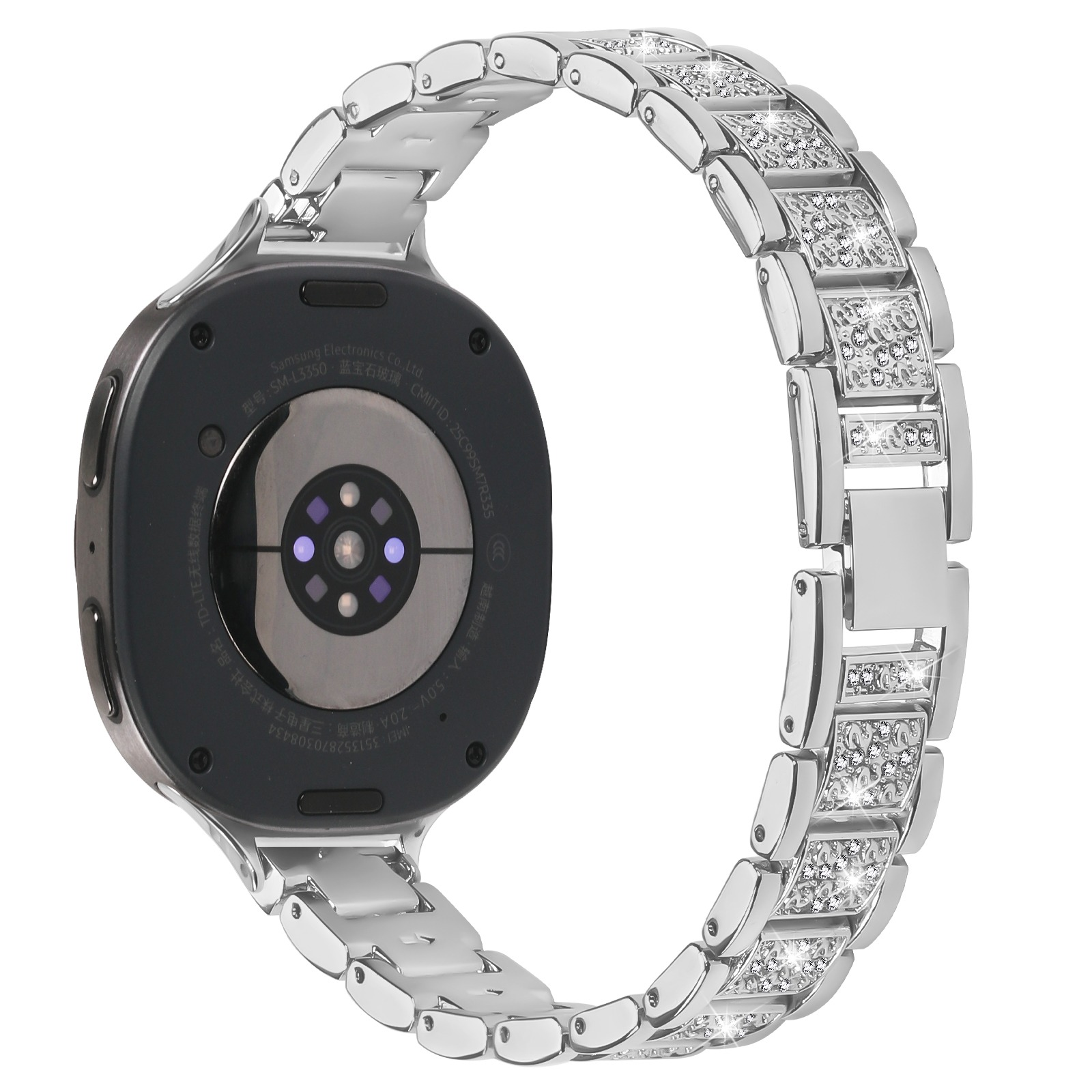 Uno smartwatch argentato con cinturino tempestato di diamanti è esposto su sfondo bianco, il retro dell'orologio è visibile.