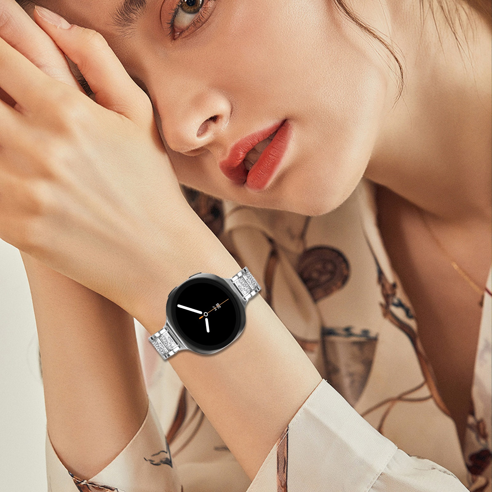 Una donna indossa uno smartwatch argentato con schermo nero. Indossa rossetto rosso e una camicia fantasia.