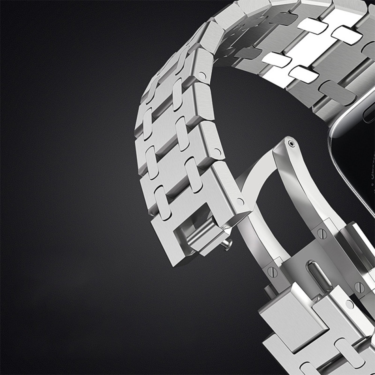 Primo piano di un cinturino d'orologio argentato. Il cinturino è composto da maglie metalliche. La chiusura è aperta. Lo sfondo è scuro.