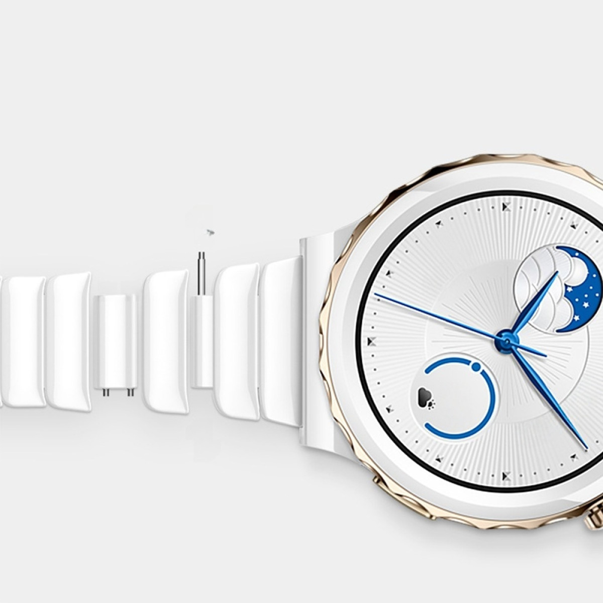 Uno smartwatch bianco con dettagli dorati. Il quadrante mostra una fase lunare e lancette blu. Parti del cinturino sono staccate.