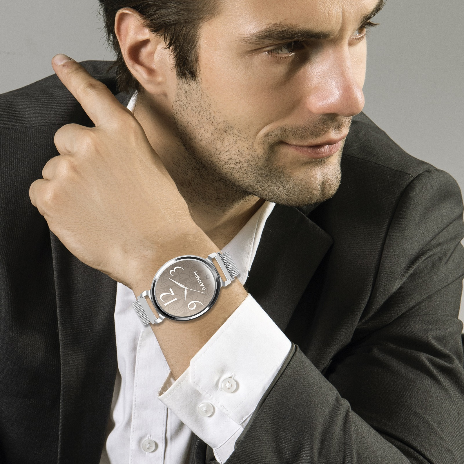Ein Mann im Anzug zeigt mit dem Finger. Er trägt eine Uhr mit Garmin-Logo und Zeitangabe.
