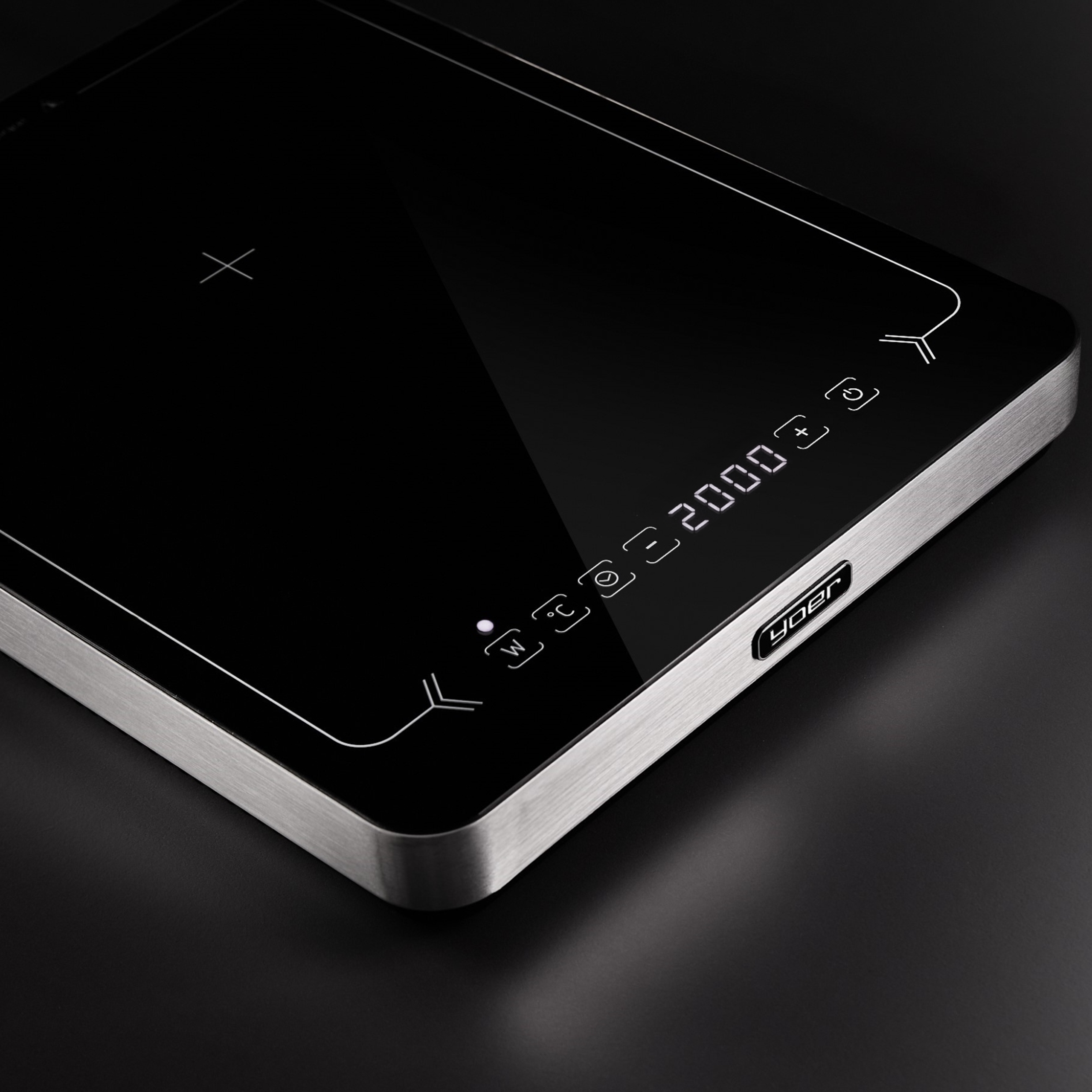 Czarna płyta indukcyjna ze srebrną ramą. Wyświetla ustawienia mocy i temperatury. Powierzchnia jest błyszcząca.