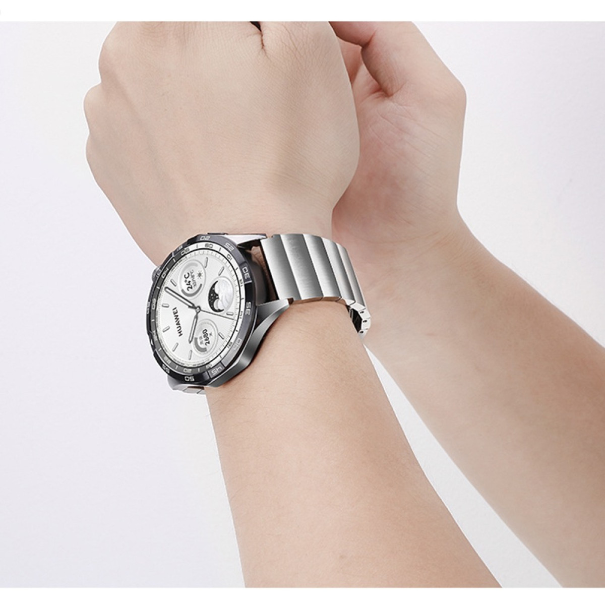 Un polso con uno smartwatch argentato. Il quadrante mostra l'ora, la temperatura e altri dati.