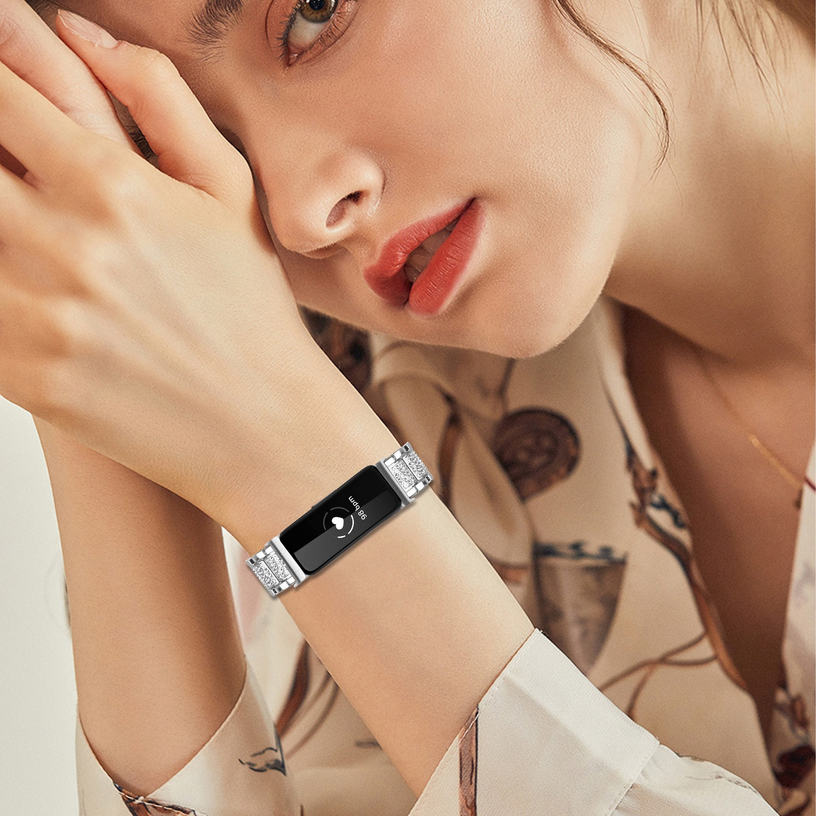 Eine Frau trägt eine Smartwatch mit silbernem Armband. Das Zifferblatt zeigt die Herzfrequenz und ein Herzsymbol.