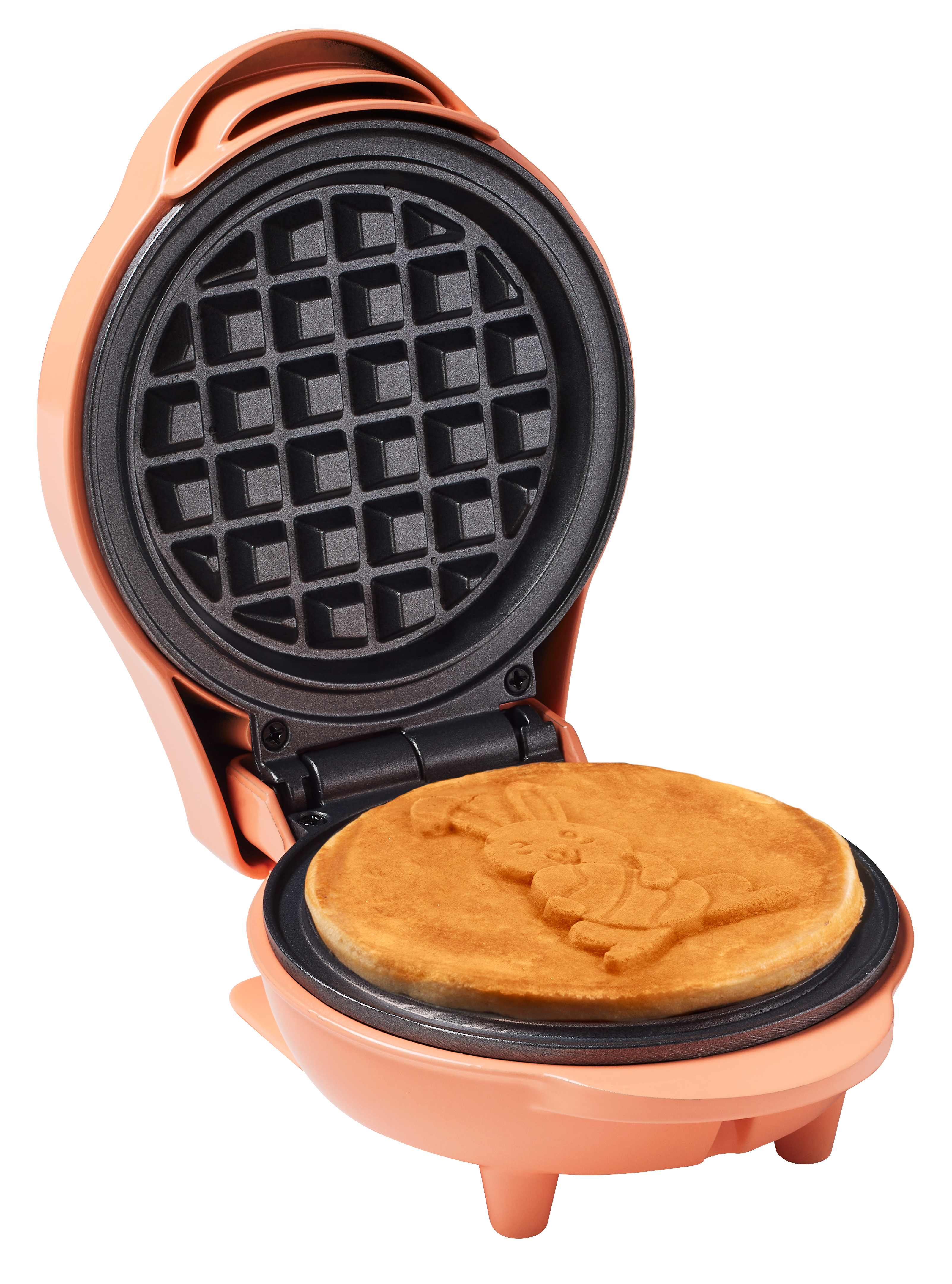 A peach-colored waffle maker is open, with a bunny-shaped waffle inside. The waffle iron is black.