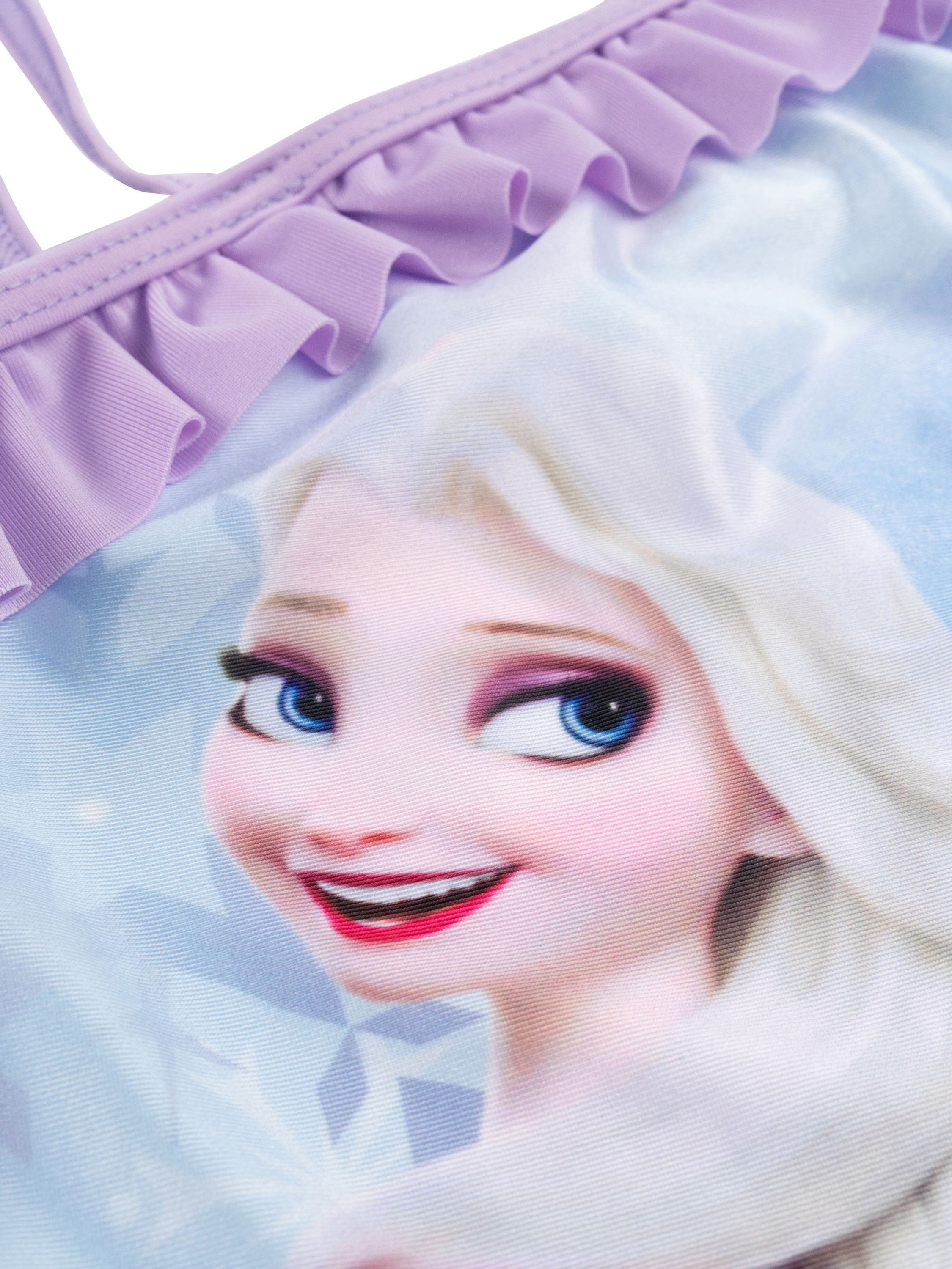Nahaufnahme eines Badeanzugs. Er zeigt Elsa aus Frozen. Das Oberteil hat lavendelfarbene Rüschen.