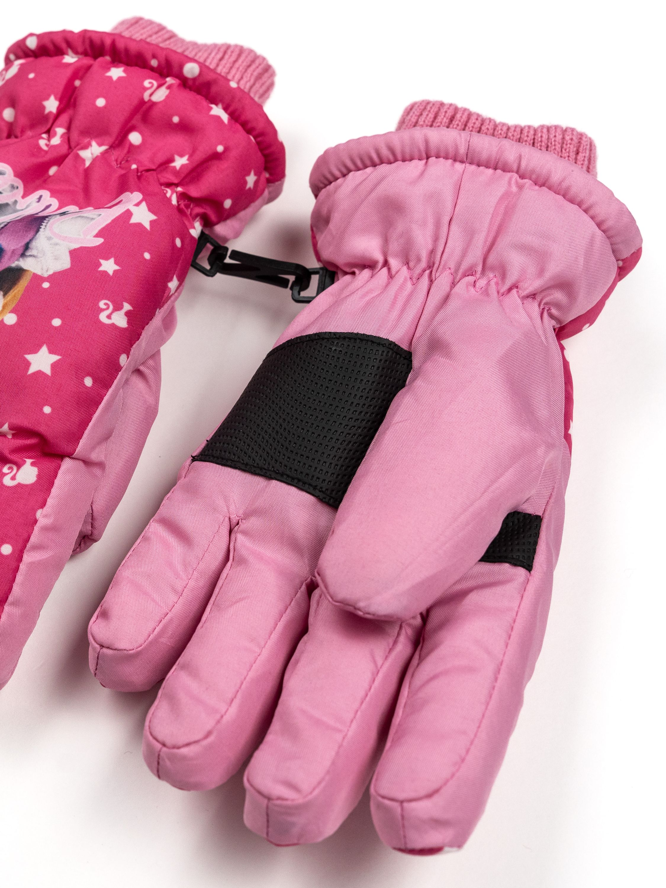 Zwei rosa Winterhandschuhe auf weißem Untergrund. Einer hat ein Einhorn-Design, der andere einen schwarzen Patch.