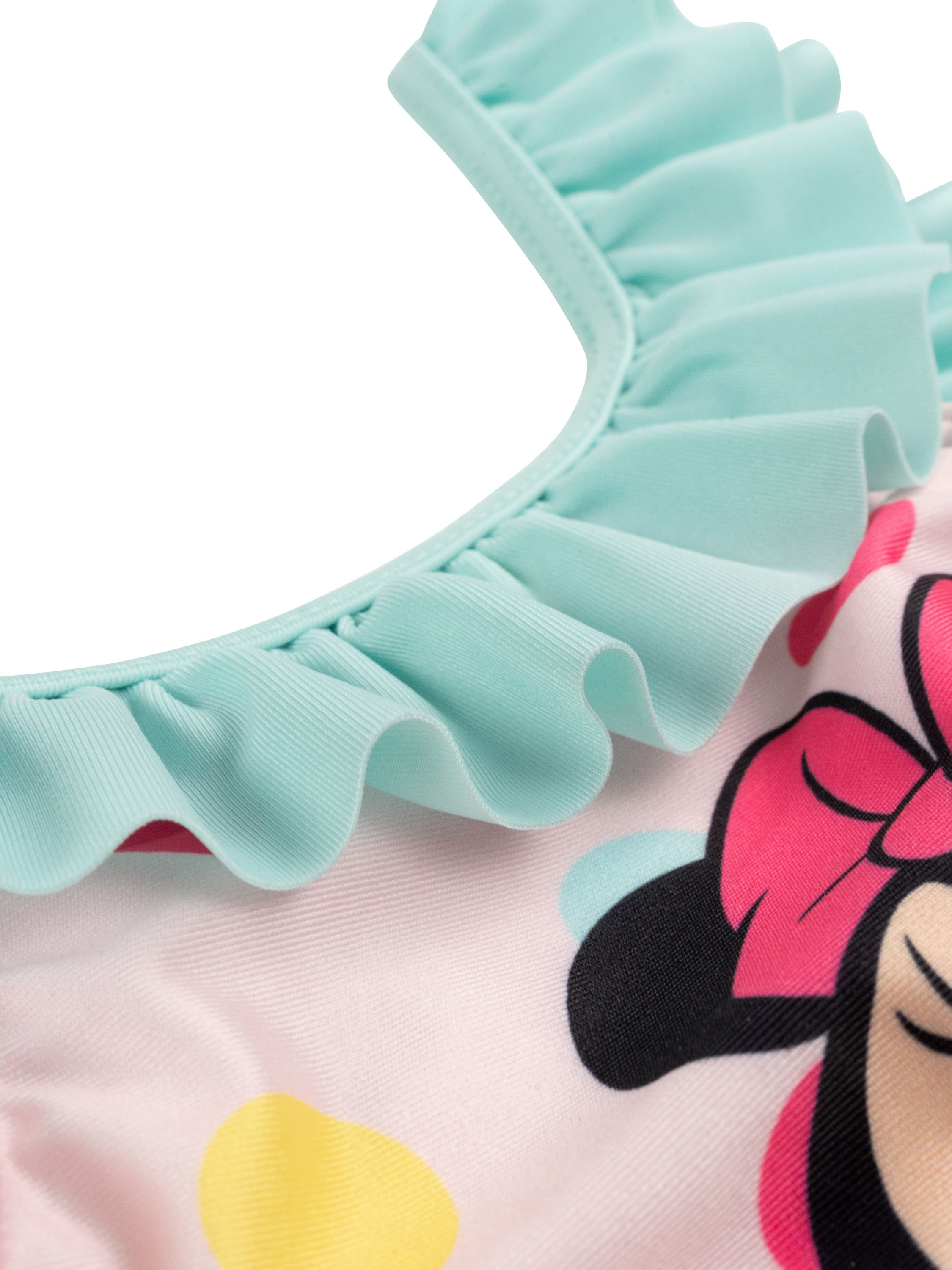Nahaufnahme eines Minnie Mouse-Badeanzugs. Er hat einen mintgrünen Rüschenkragen und einen rosa-weißen Körper mit Punkten.