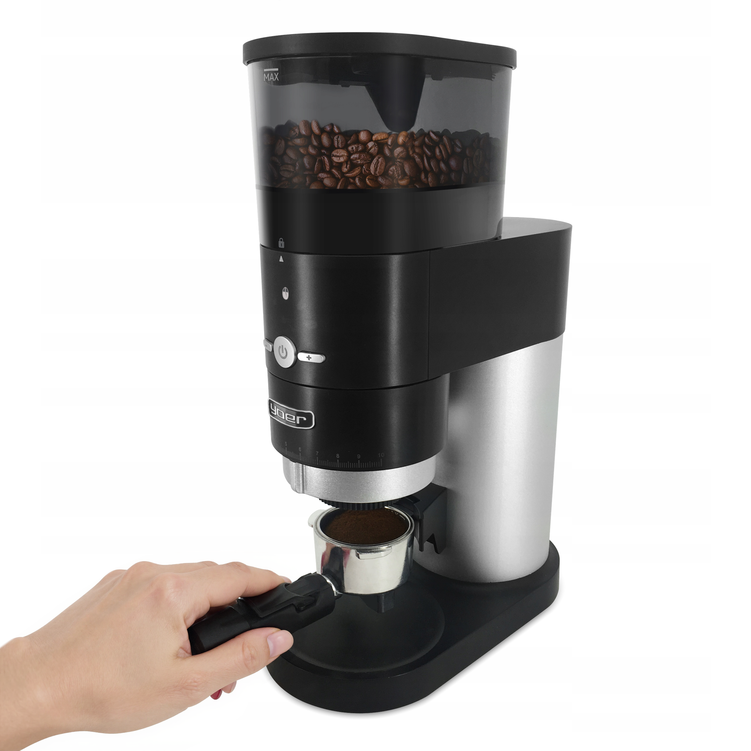 Młynek do kawy z ziarnami kawy u góry, kolbą na dole i dłonią trzymającą kolbę.