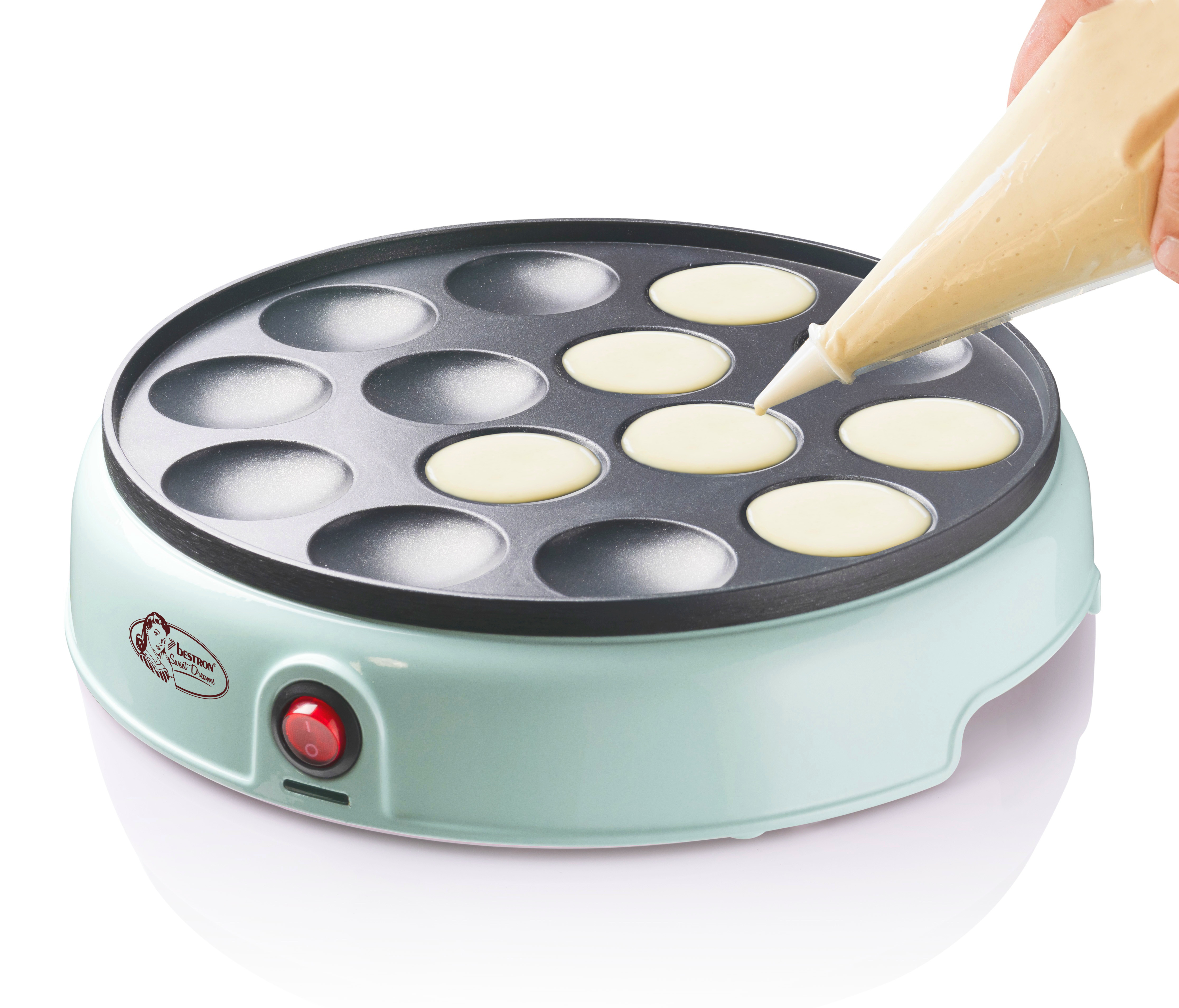 Osoba wlewa ciasto z worka cukierniczego do maszyny do naleśników. Urządzenie jest włączone.