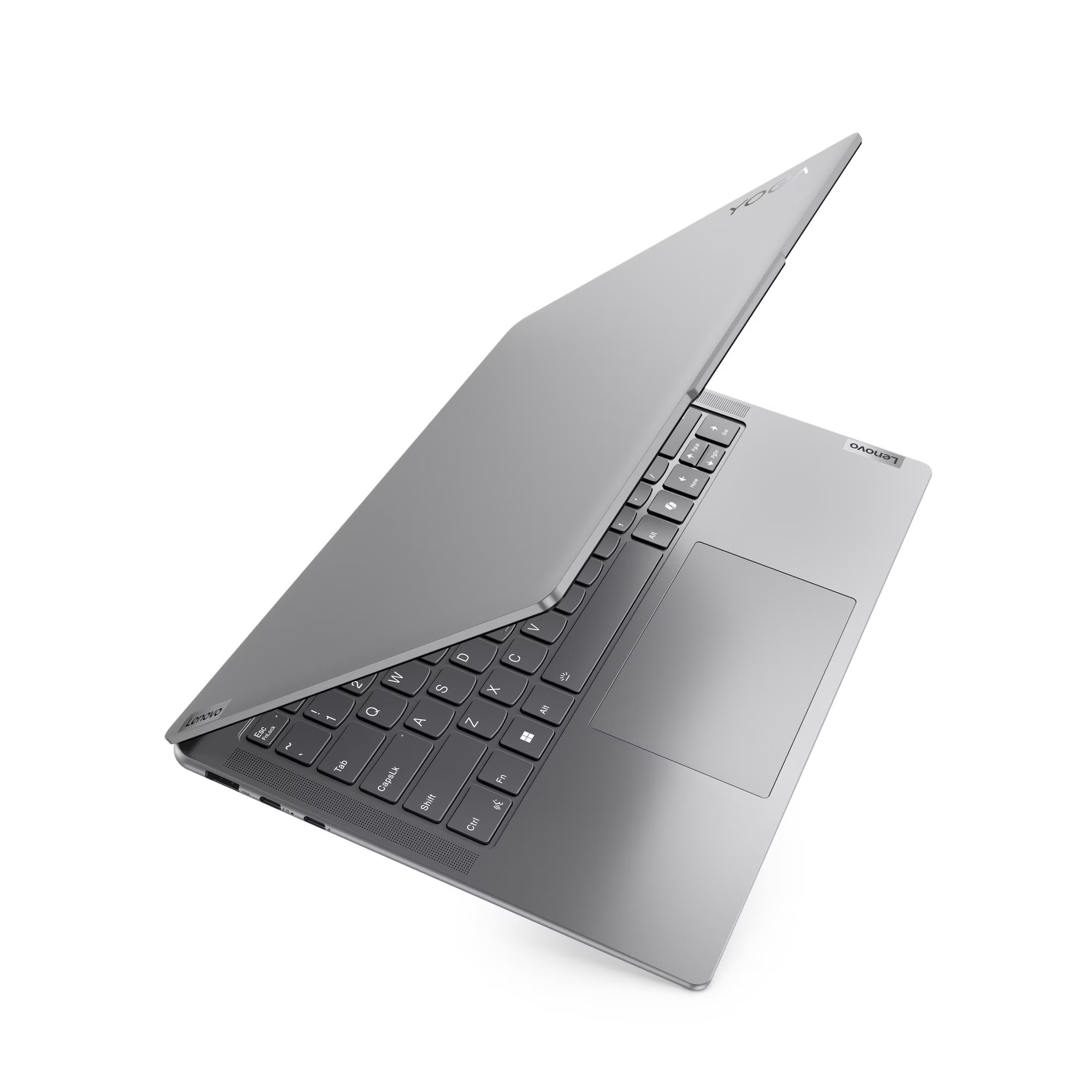 Un laptop Lenovo grigio è aperto su una superficie bianca. La tastiera è visibile, con lo schermo leggermente sollevato.