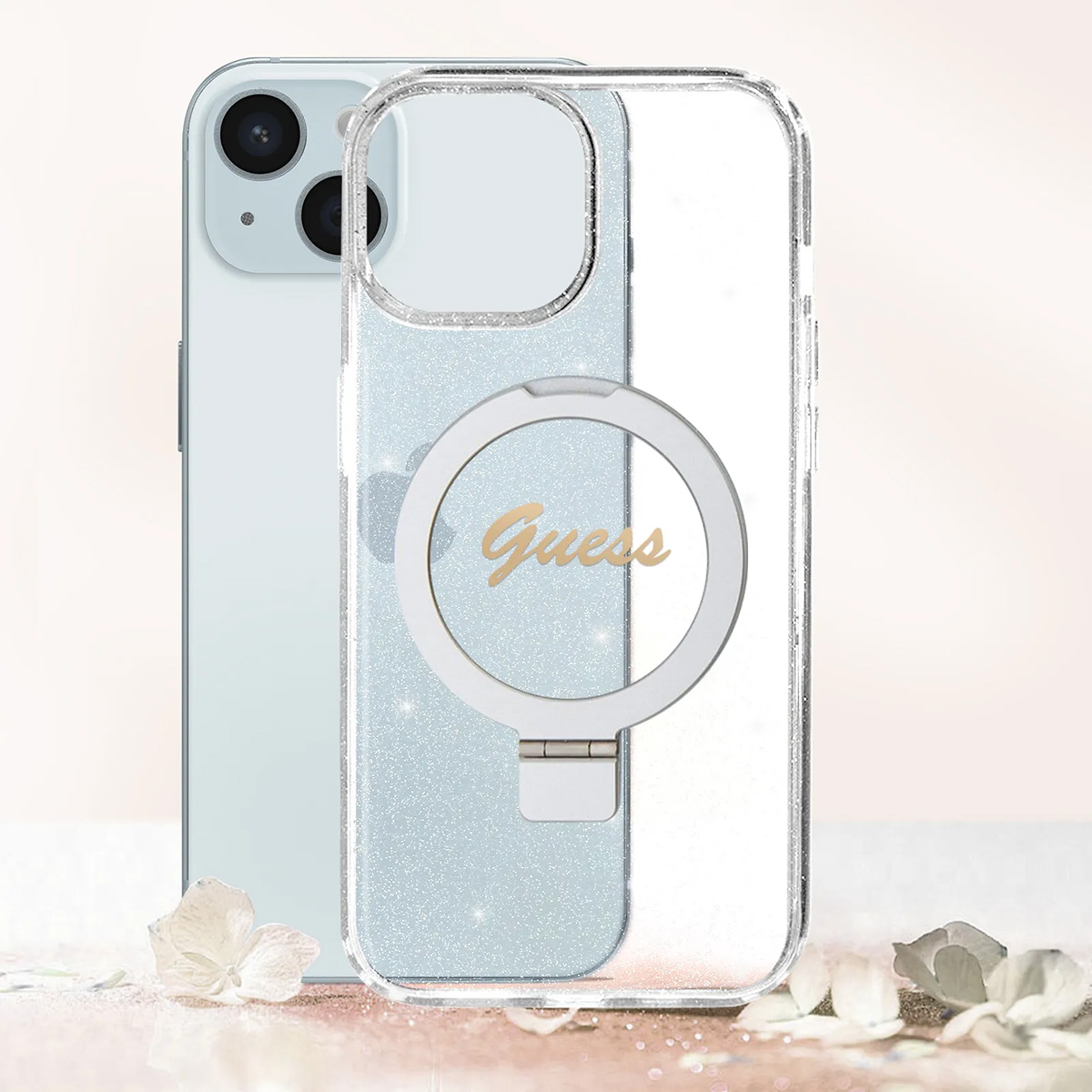 Un iPhone con una custodia trasparente Guess. La custodia ha un supporto ad anello. Lo sfondo è bianco, con petali di fiori.