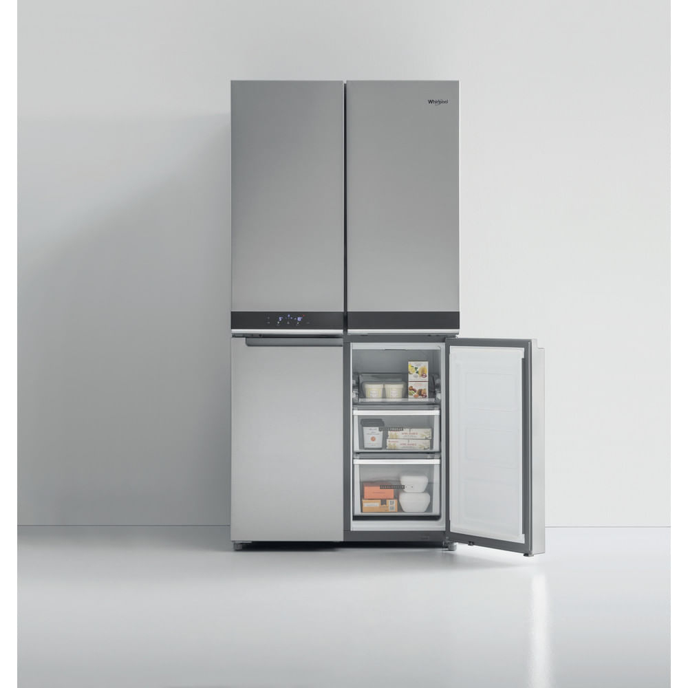 Un refrigerador Whirlpool de acero inoxidable con cuatro puertas. La puerta inferior derecha está abierta, mostrando comida.