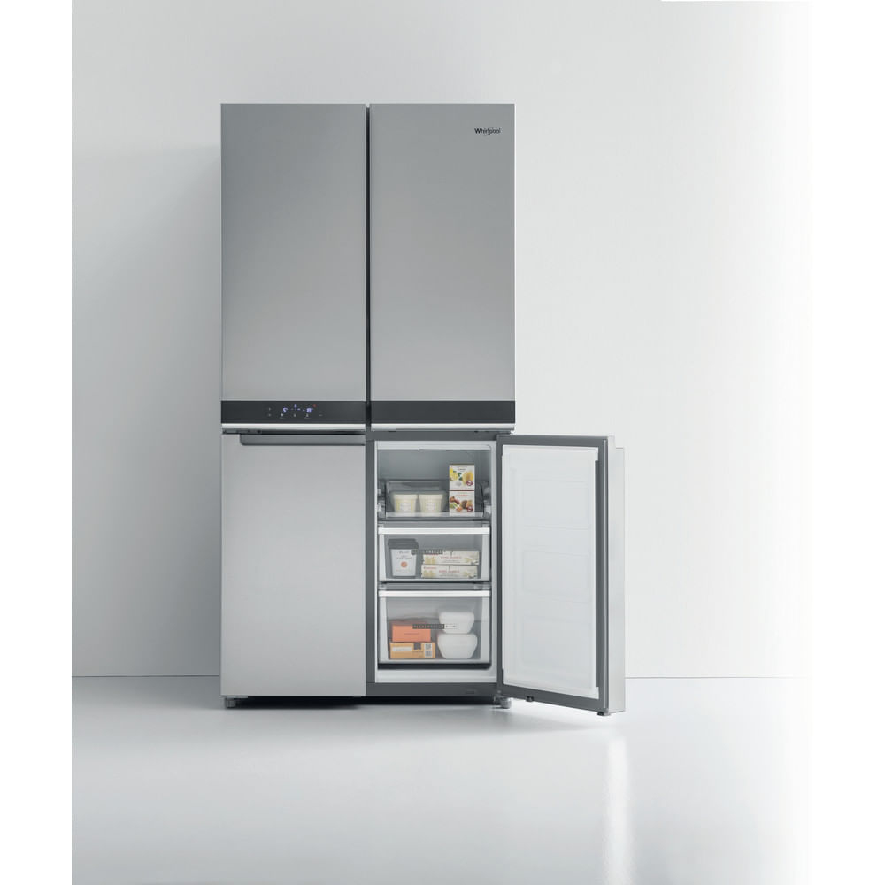 Un refrigerador Whirlpool plateado y moderno con cuatro puertas. La puerta inferior derecha está abierta, mostrando estantes con alimentos.