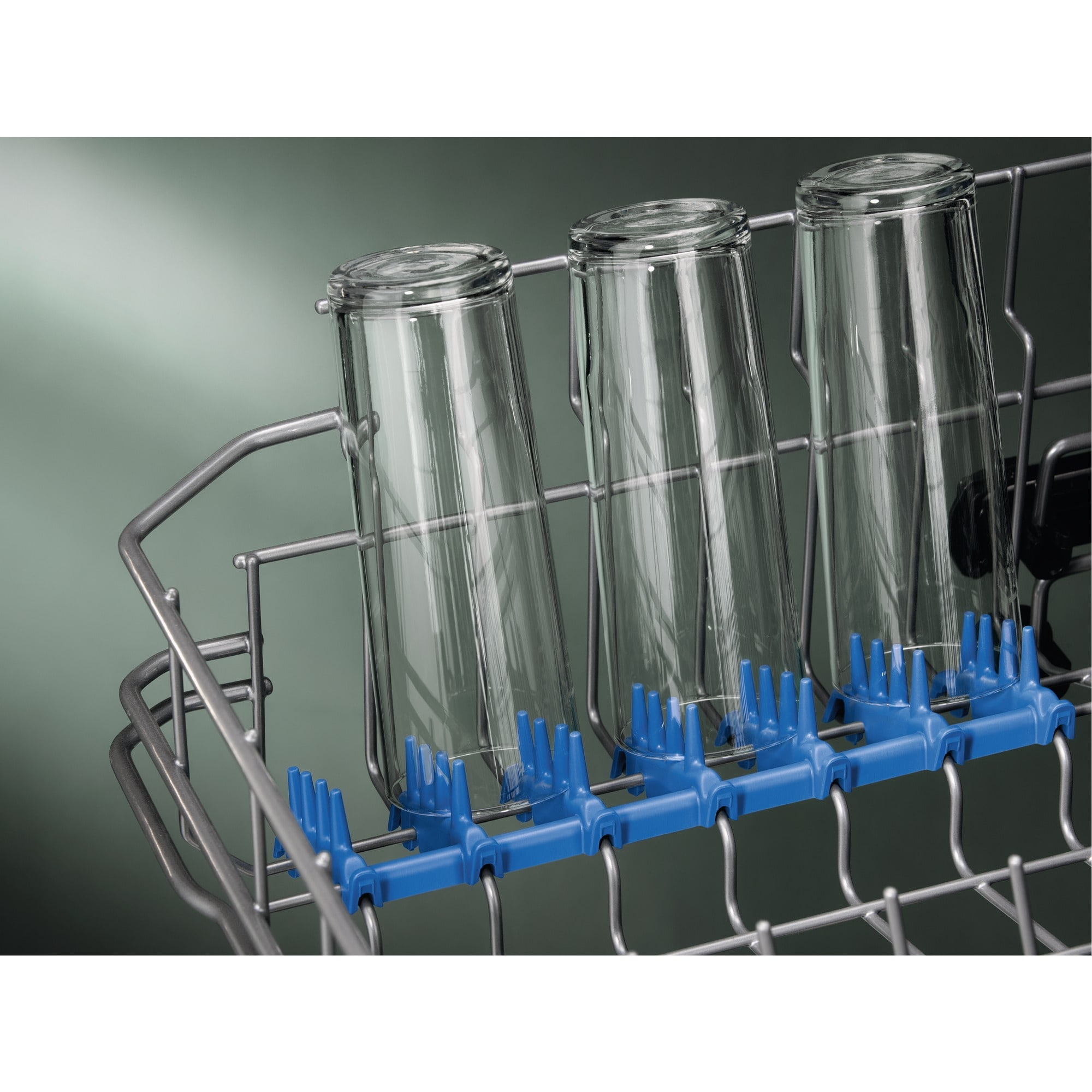 Tre bicchieri trasparenti all'interno di una lavastoviglie. Sono capovolti in un supporto di plastica blu in un rack metallico.