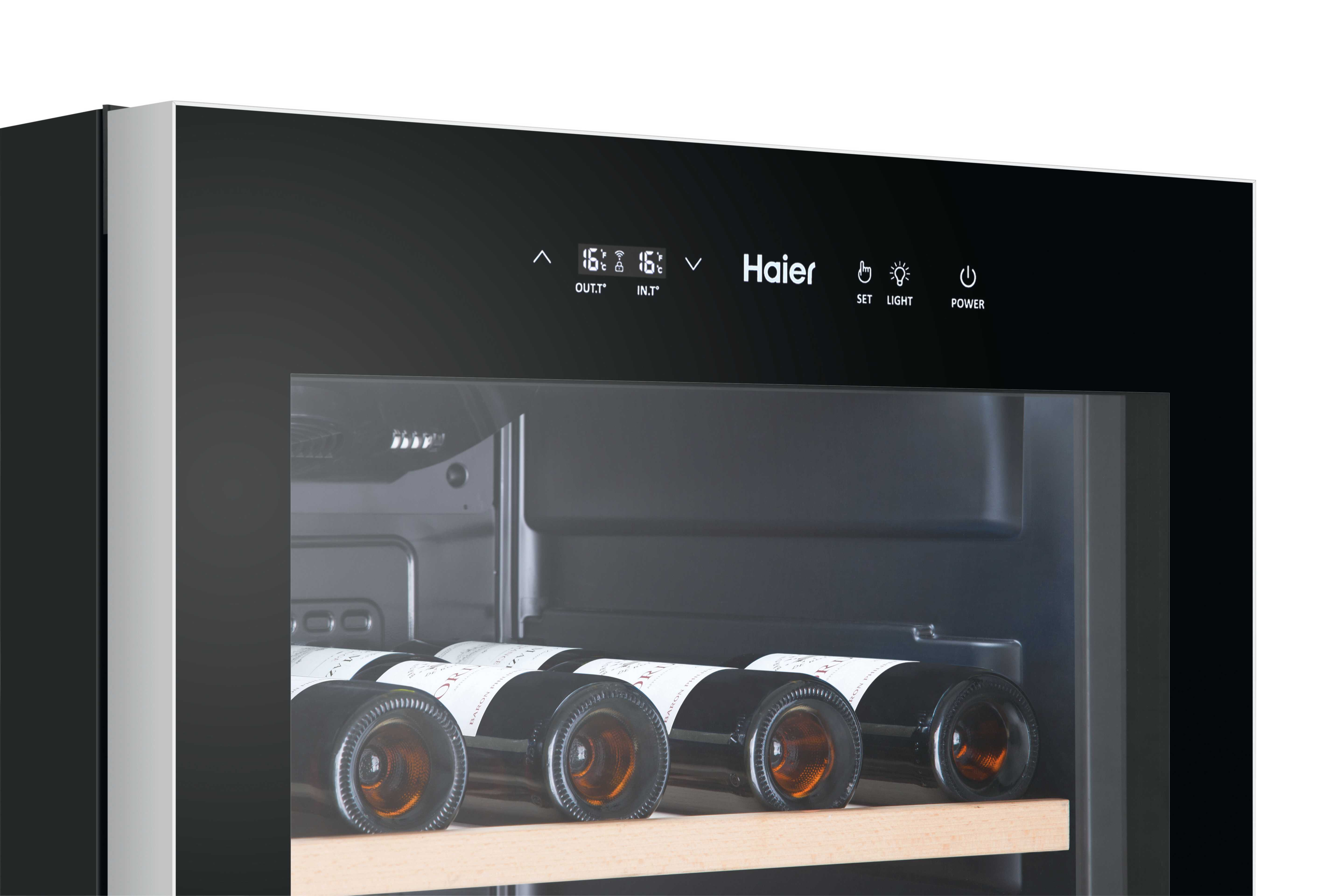 Chłodziarka do wina z butelkami wina w środku. Chłodziarka ma wyświetlacze cyfrowe i logo Haier.