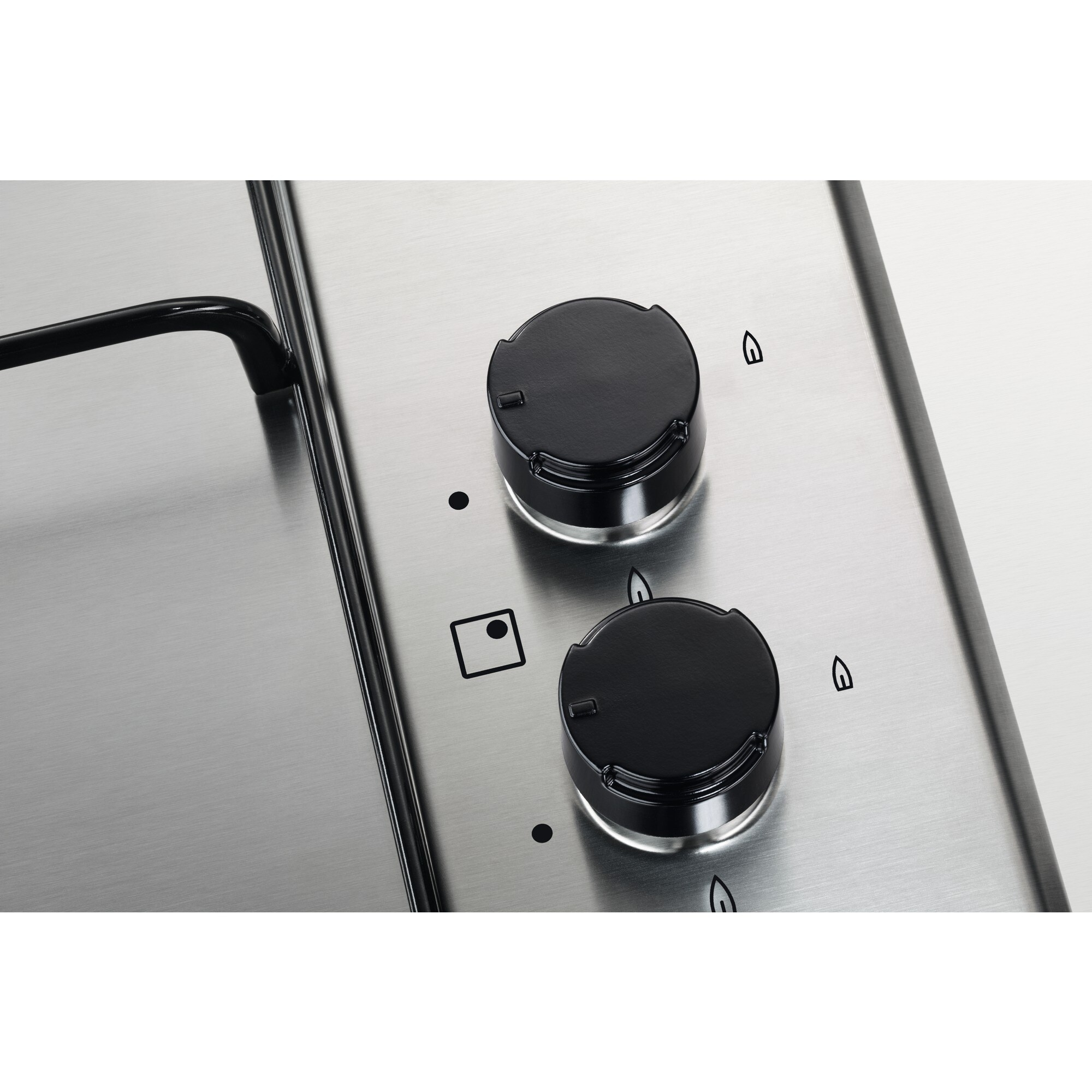 Zbliżenie na stalową płytę grzejną z dwoma czarnymi pokrętłami i wskaźnikami palnika.