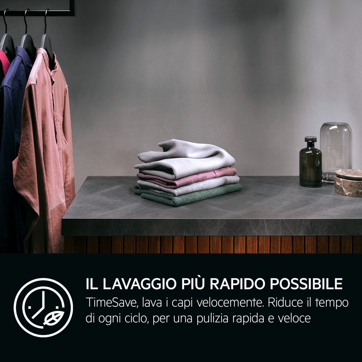 Abiti piegati su un tavolo, camicie appese. Una bottiglia scura e un barattolo di vetro dietro. Testo: Lavaggio veloce.