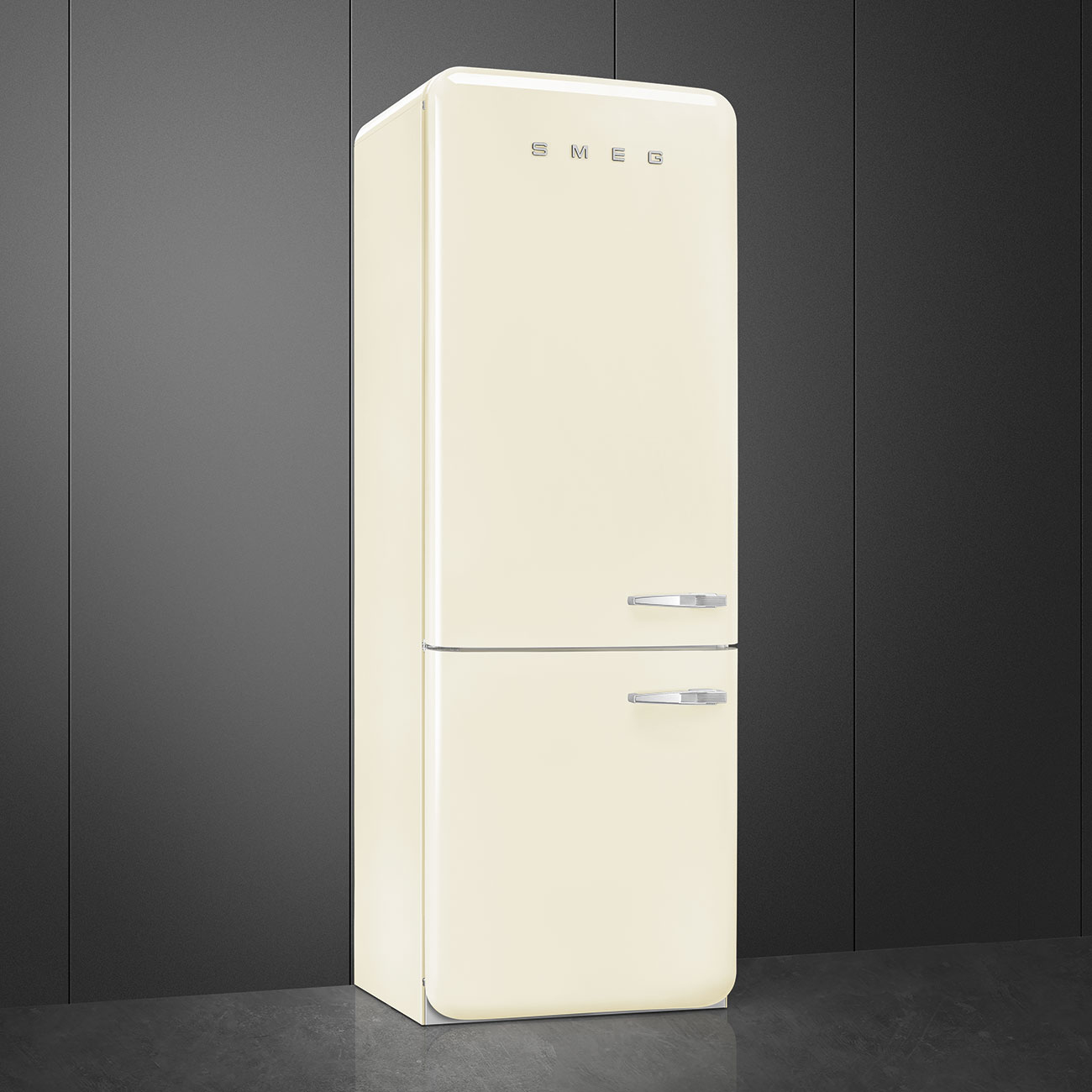 Un refrigerador retro crema contra una pared gris oscura. Se ven manijas cromadas y el logo SMEG.