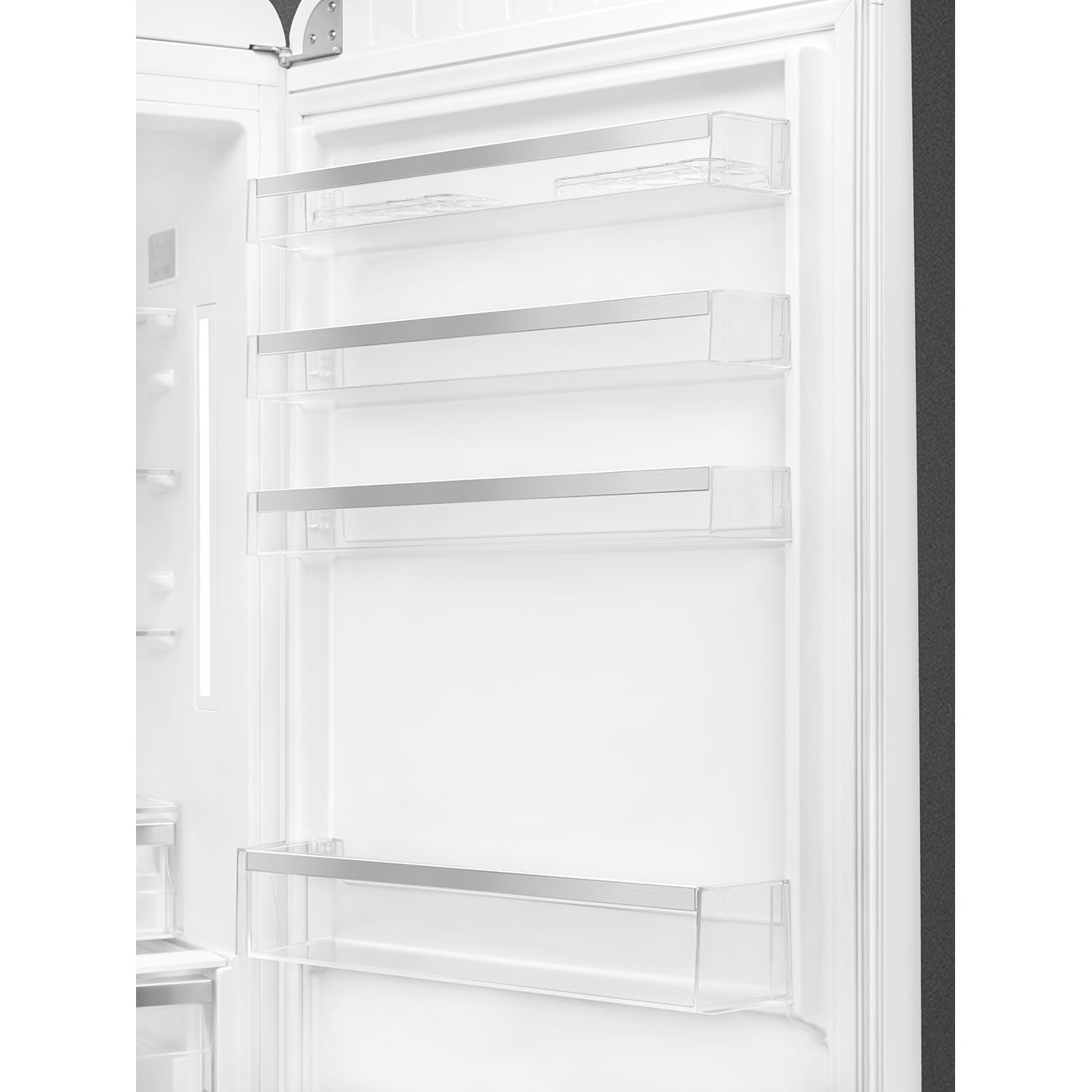 Interior de refrigerador abierto con estantes transparentes y detalles metálicos. La puerta está abierta, revelando compartimentos y estantes vacíos.