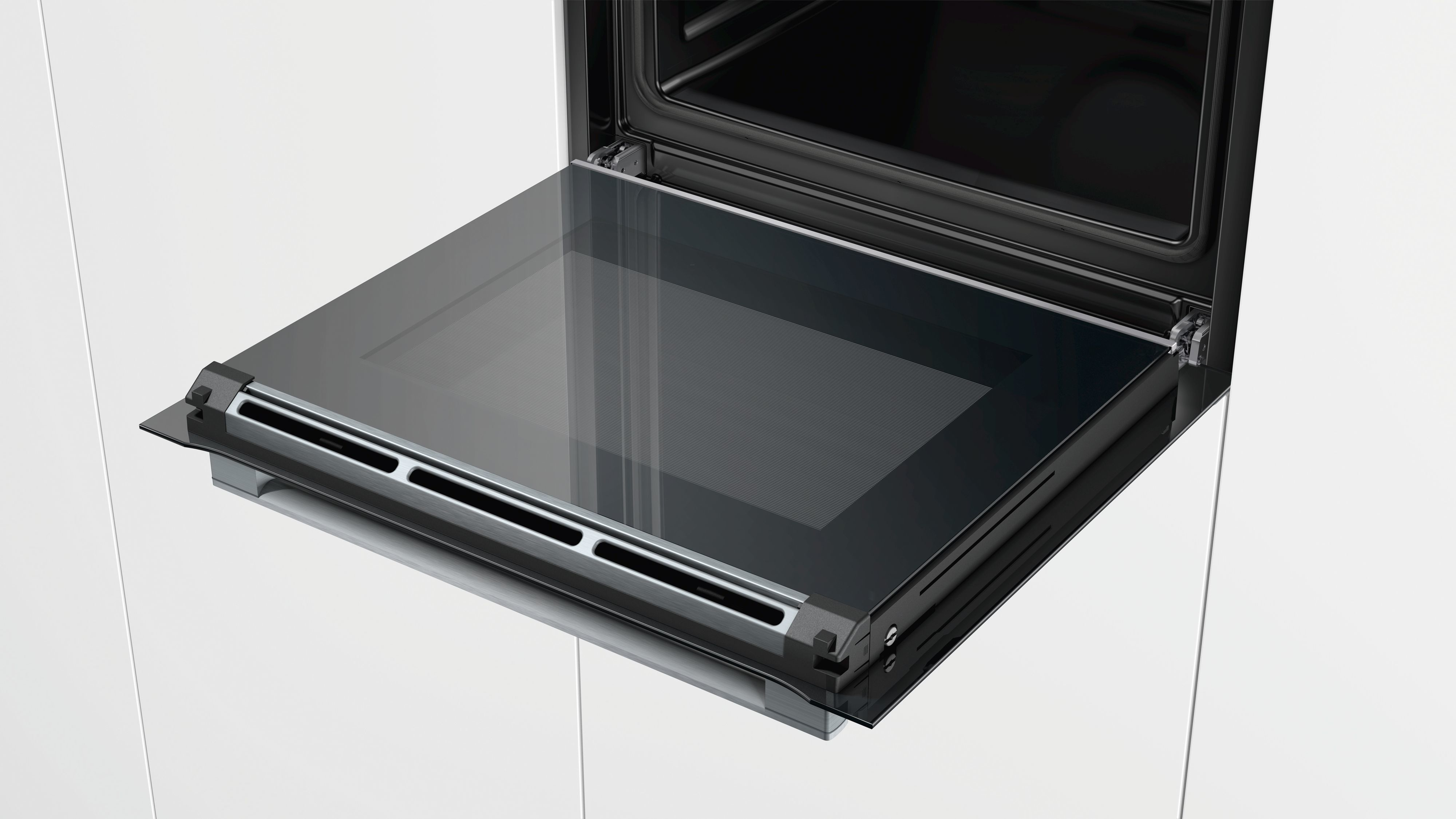 Offene Backofentür mit Glasfront. Schwarzer Backofeninnenraum sichtbar. Weiße Schrankseite.