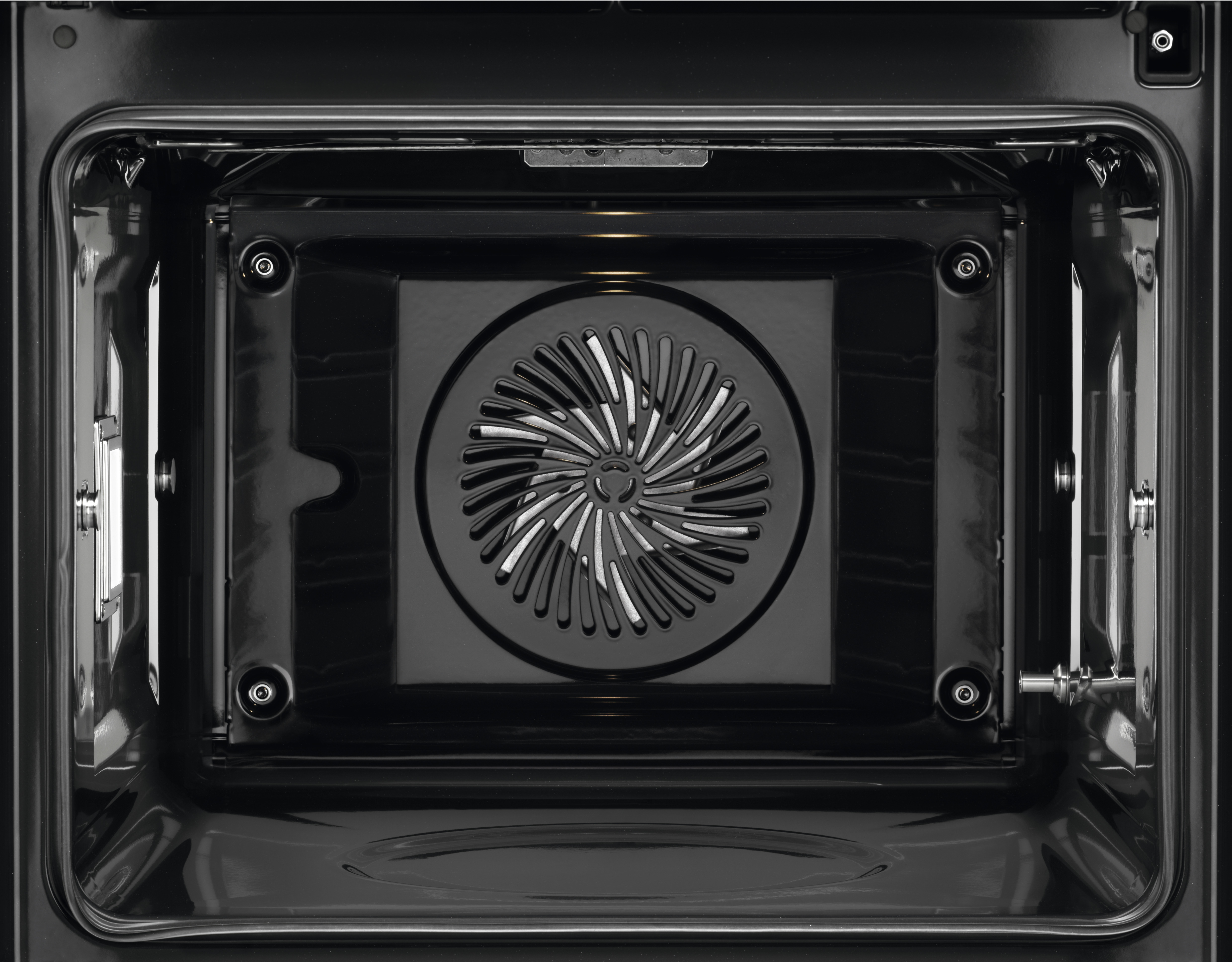 Interno di un forno nero. Una ventola è al centro. Il forno ha una superficie nera lucida.