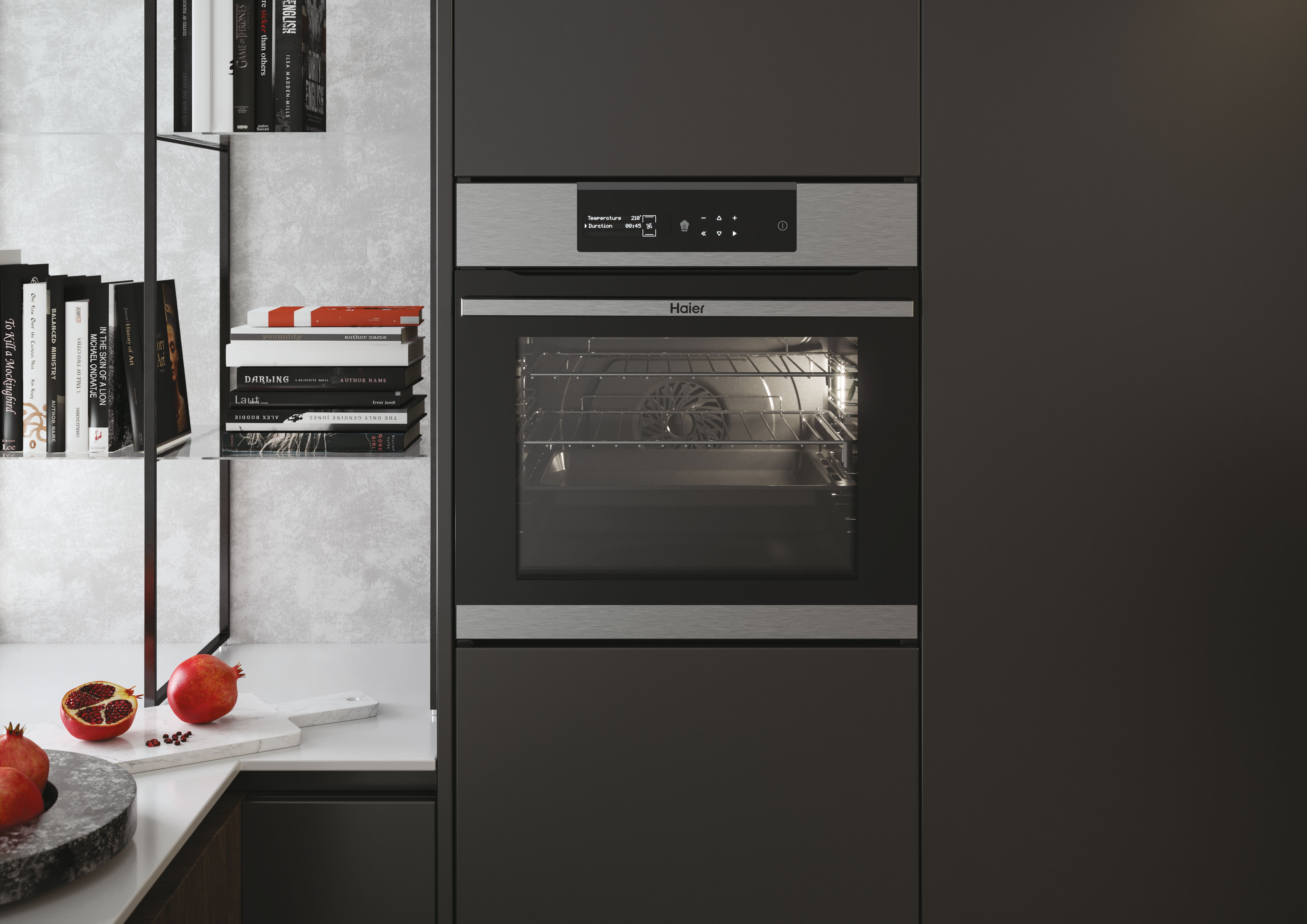 Un forno con display digitale, circondato da mobili scuri. Melograni e libri sono anche nella scena.