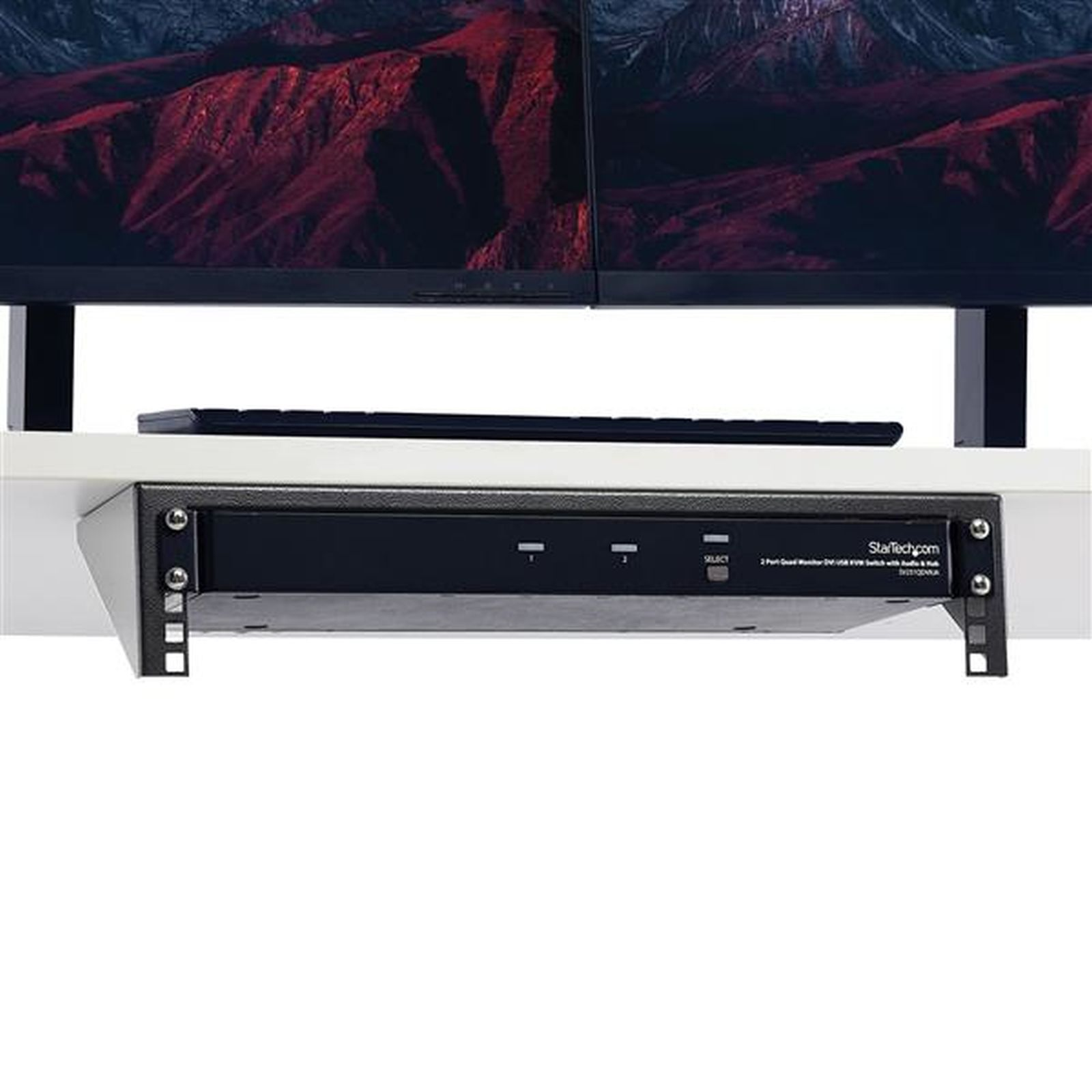 Una configuración de escritorio con dos monitores que muestran una escena de montaña. Un teclado y un dispositivo StarTech visibles.