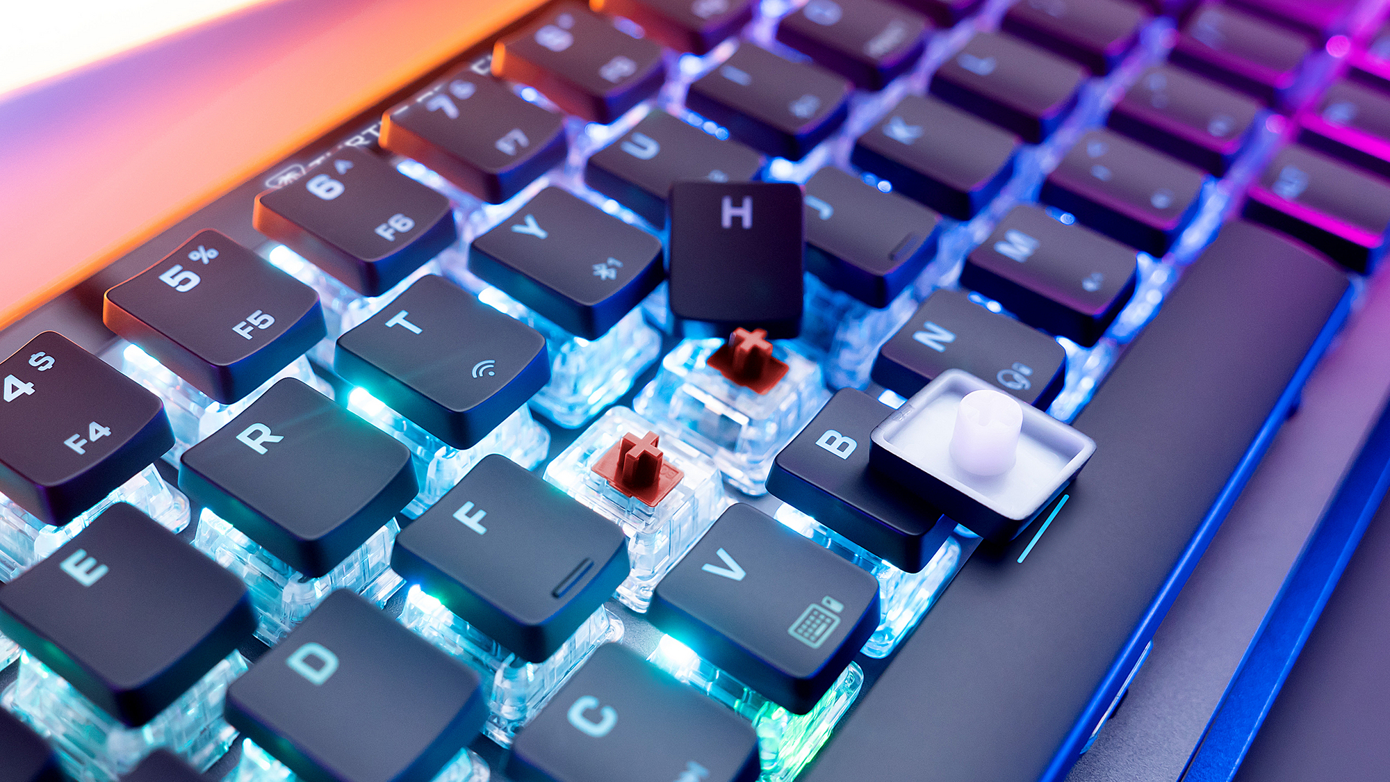Nahaufnahme einer mechanischen Tastatur. Schwarze Tasten mit weißen Buchstaben. Einige Tasten entfernt, Schalter und LED-Leuchten sichtbar.