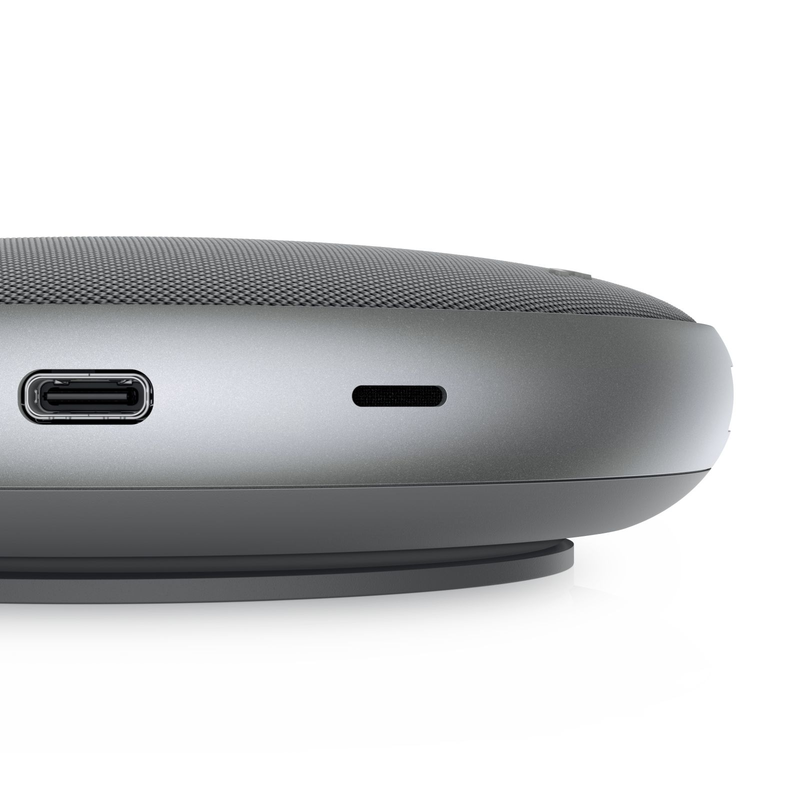 Nahaufnahme eines silbernen Lautsprechers mit USB-C-Anschluss und kleinem Loch. Die Oberseite ist mit Mesh bedeckt.