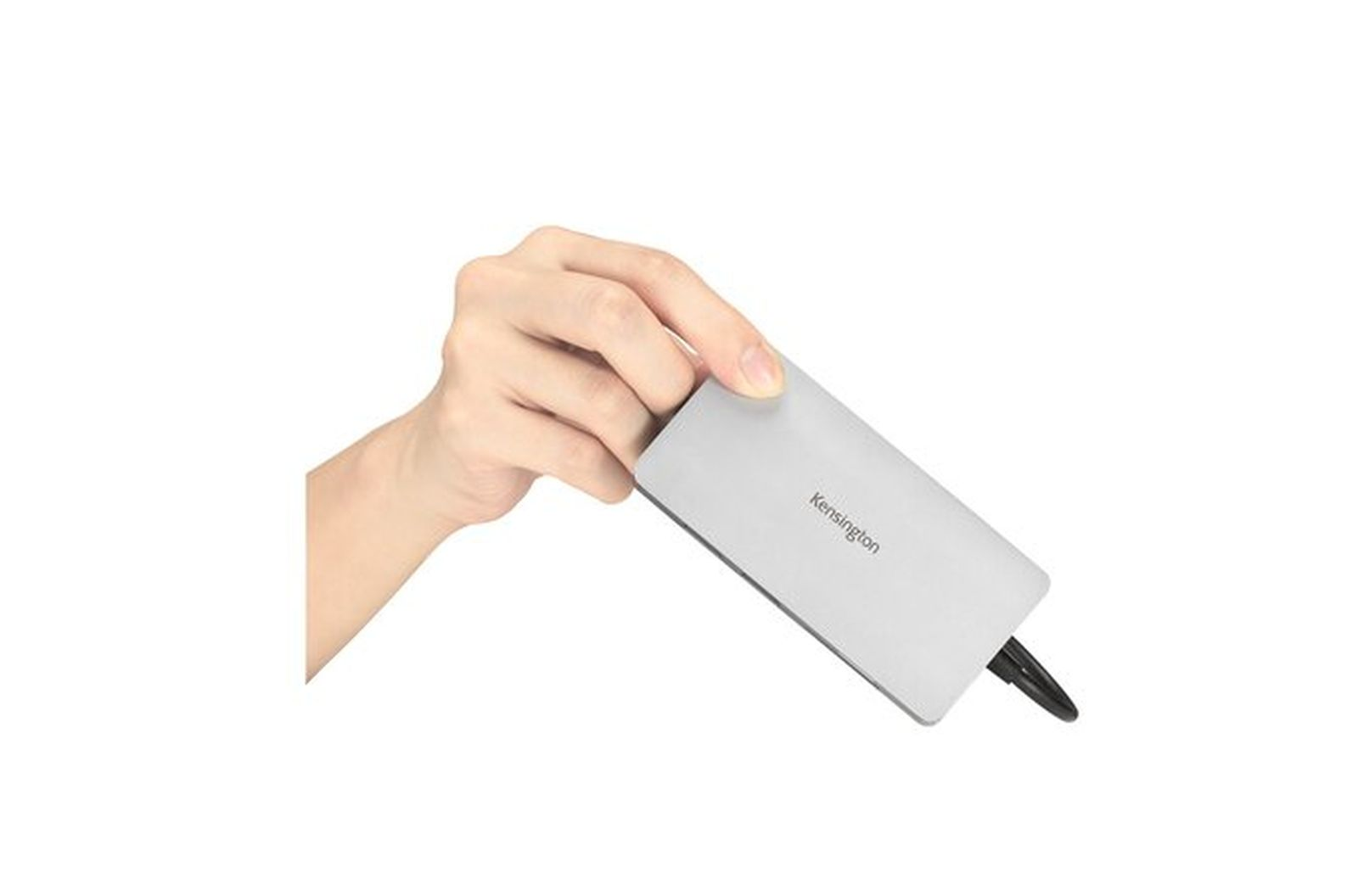 Una mano tiene un dispositivo Kensington argento con cavo nero su sfondo bianco.