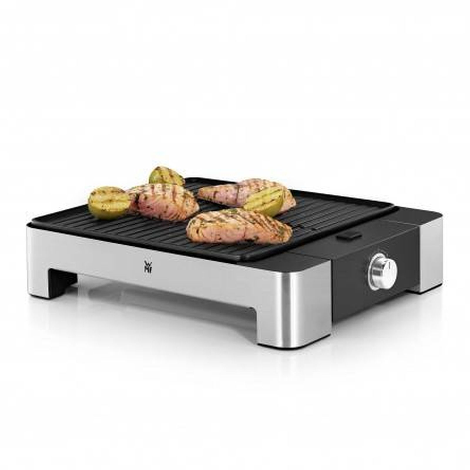 Un grill électrique avec de la nourriture dessus. Du saumon et des pommes de terre grillent sur la surface noire.