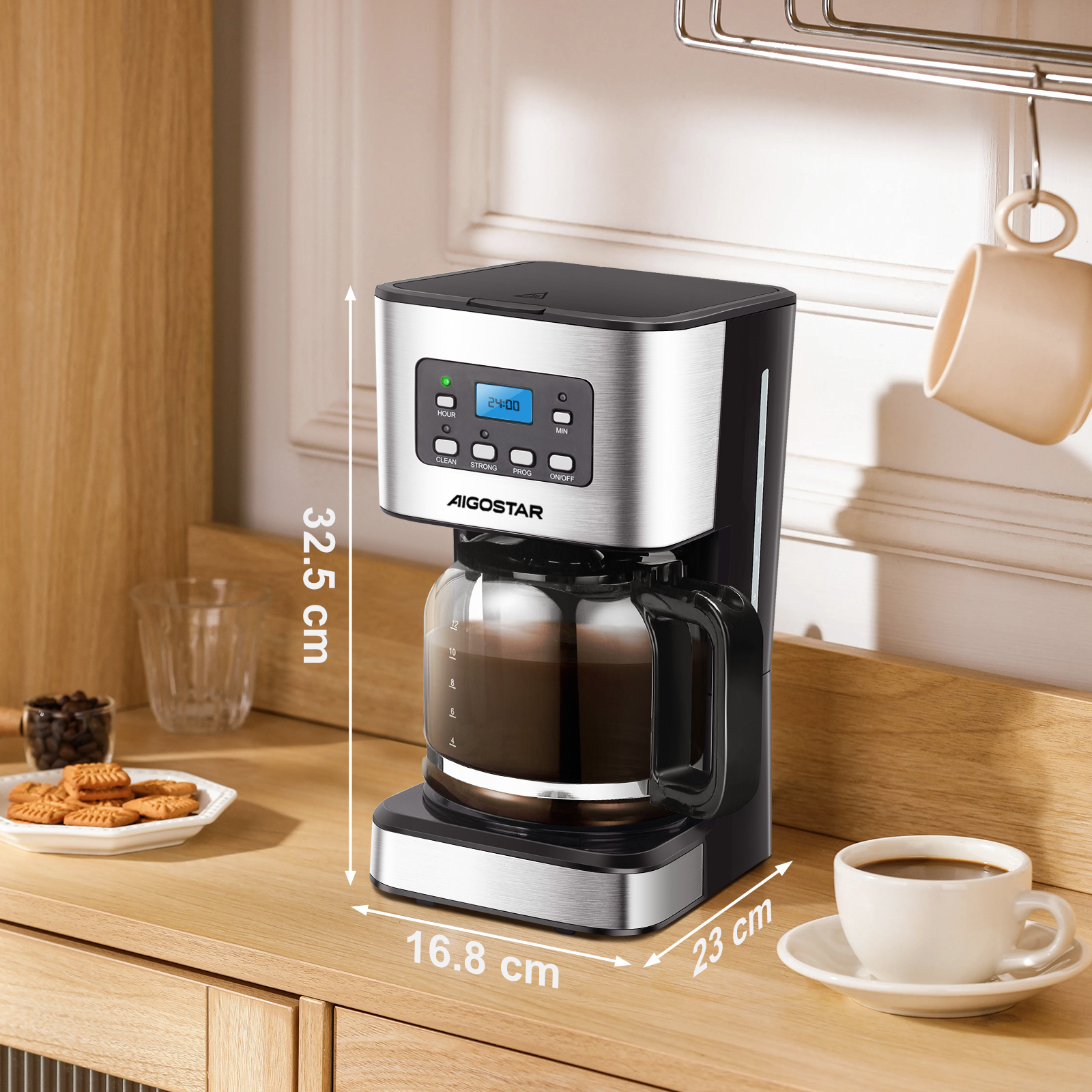 Una cafetera con jarra de vidrio, una taza de café, galletas y granos de café sobre una superficie de madera.