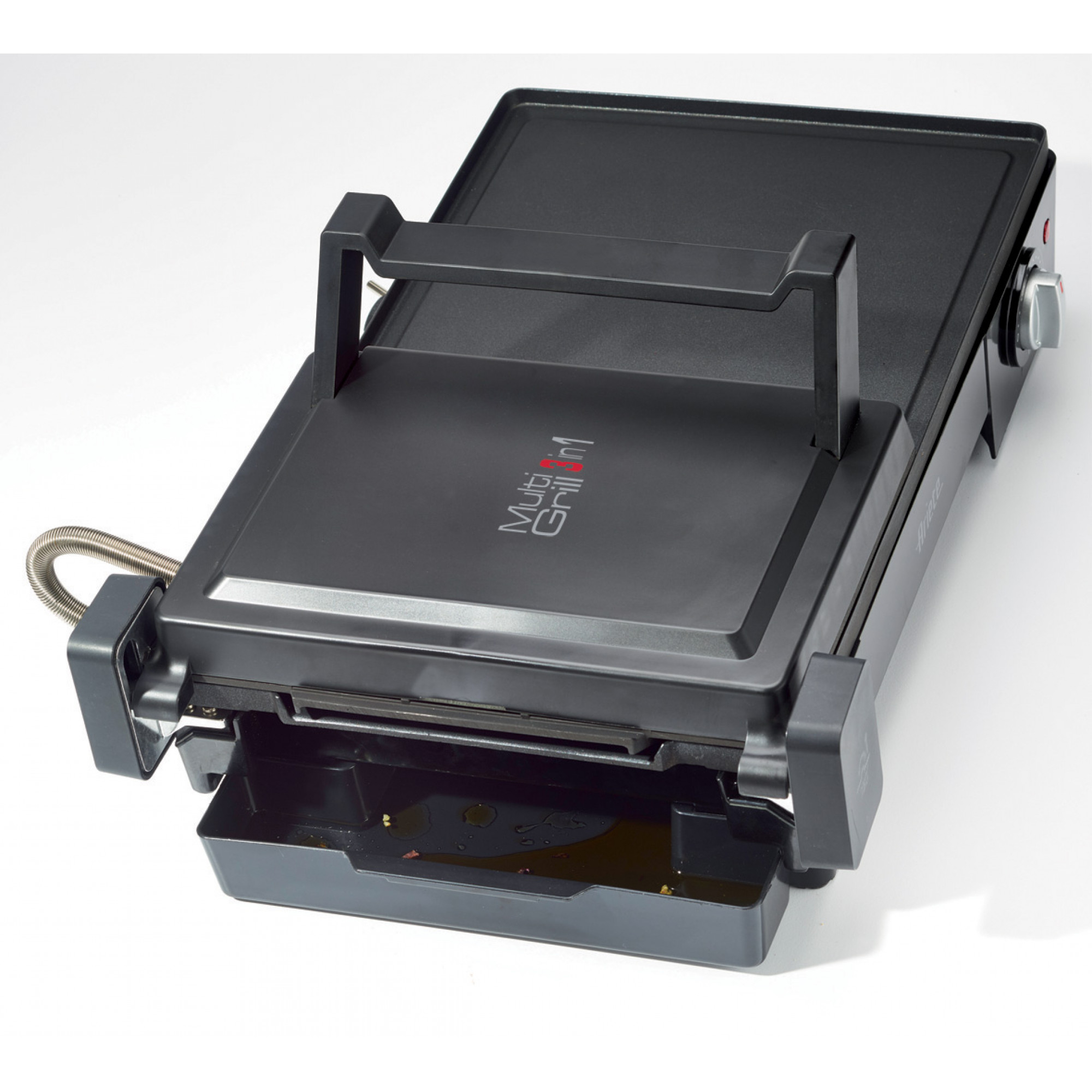 A black multi-grill on a white surface. It has a handle, a control knob, and an oil tray. The brand name is visible.