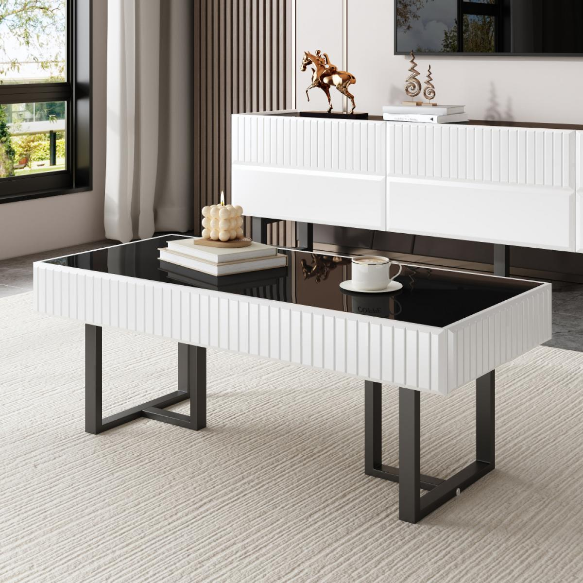 Modernes Wohnzimmer mit weißem Couchtisch, schwarzer Platte und dunklen Beinen. Eine Kaffeetasse und eine Kerze stehen auf dem Tisch.