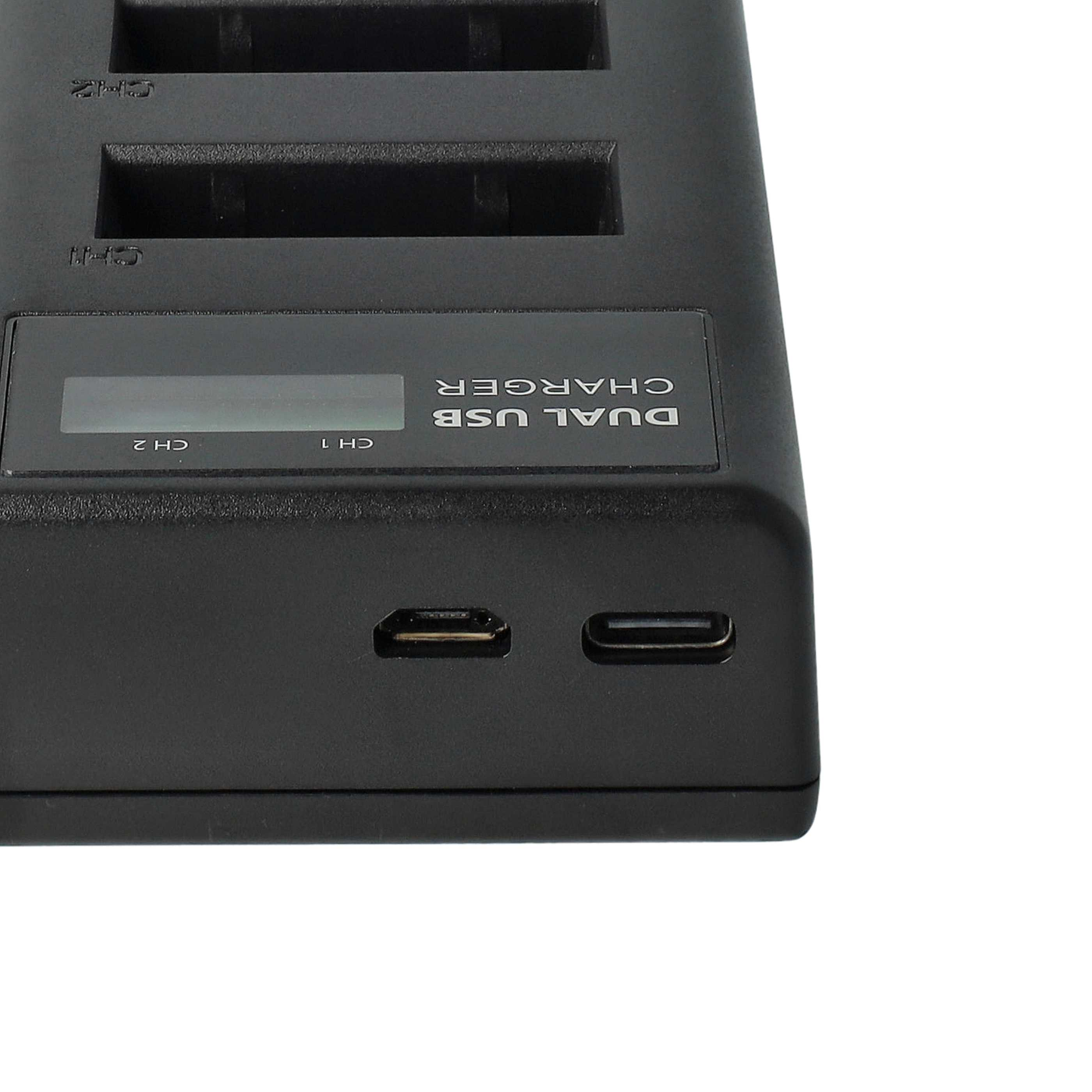 Schwarzes Dual-USB-Ladegerät mit zwei Ladeschlitzen, einem Display und USB-Anschlüssen. Weißer Hintergrund.