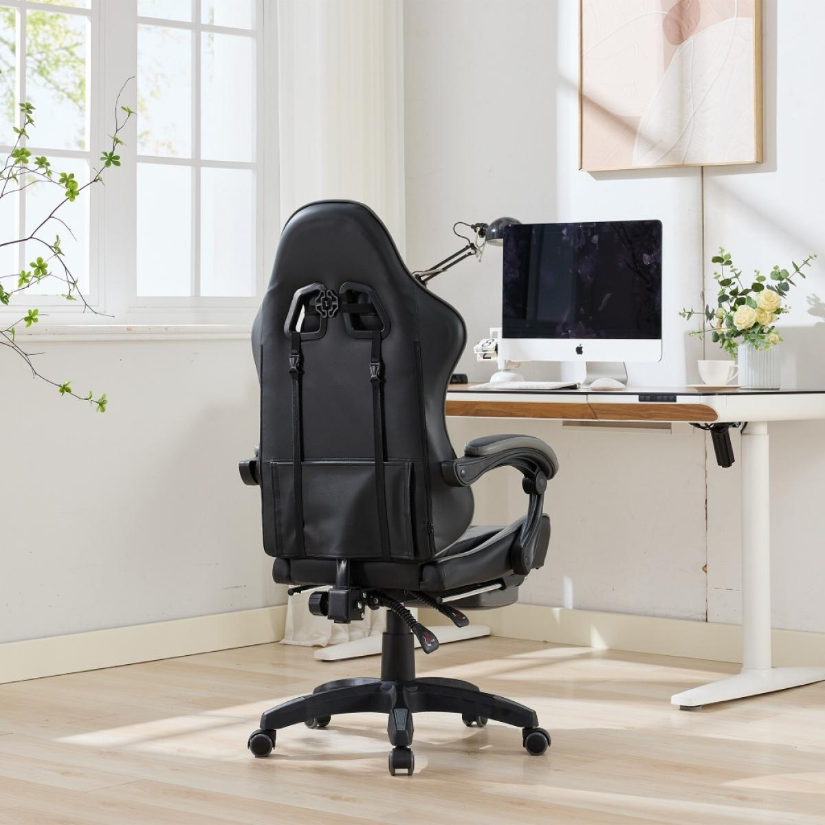 Ein schwarzer Gaming-Stuhl ist von einem Schreibtisch mit Computer abgewandt. Im Hintergrund sind Fenster, Kunst und Blumen zu sehen.