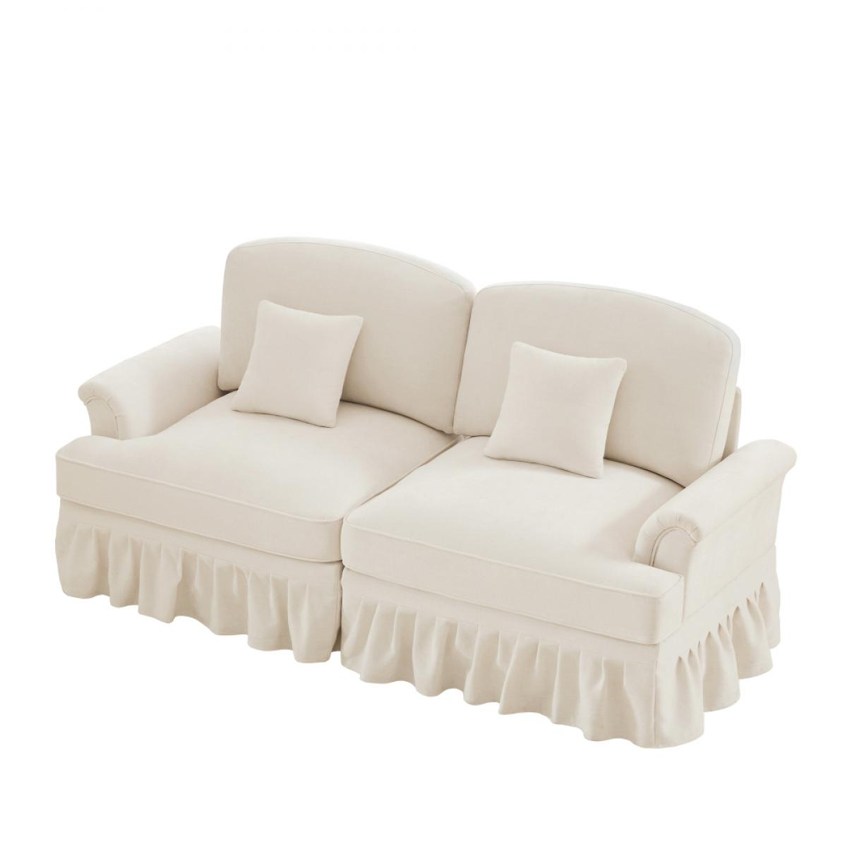 Cremefarbenes Sofa mit zwei Teilen, zwei Kissen und Rüschenrock. Der Hintergrund ist weiß.