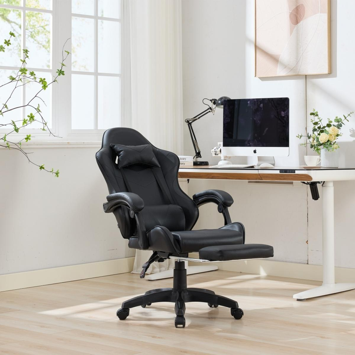 Ein schwarzer Gaming-Stuhl mit Fußstütze steht vor einem weißen Schreibtisch. Ein Computer, eine Lampe und Blumen stehen auf dem Schreibtisch.