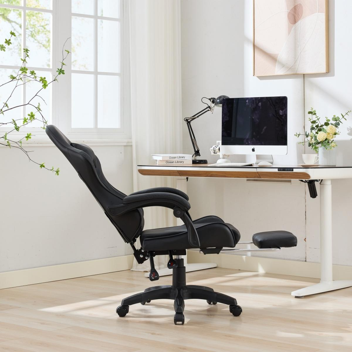Ein schwarzer Gaming-Stuhl ist zu einem Schreibtisch ausgerichtet. Auf dem Schreibtisch stehen ein Computer, eine Lampe und Blumen. Im Hintergrund befinden sich ein Fenster und Kunst.