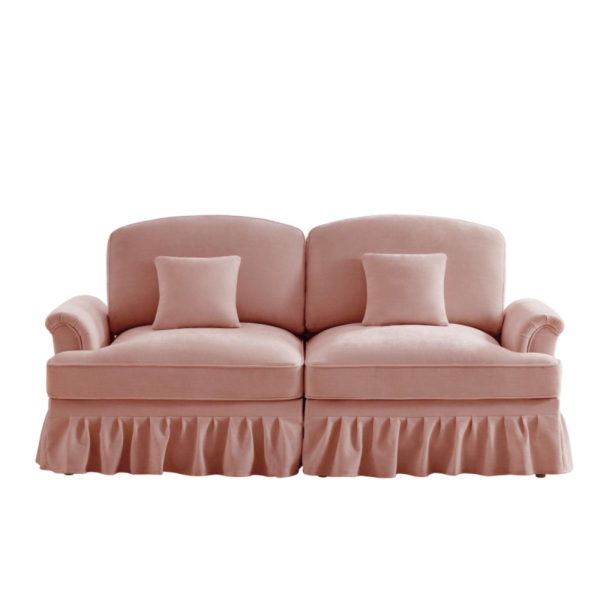 Ein rosa Sofa mit zwei Kissen. Das Sofa hat eine gerüschte Basis und vor weißem Hintergrund.