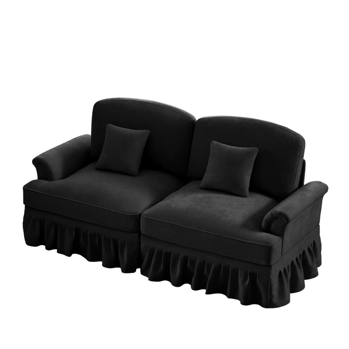 Ein schwarzes Samtsofa mit zwei Abschnitten, jeweils mit einem Kissen. Es hat Rüschenrock-Details und geschwungene Armlehnen, vor weißem Hintergrund.