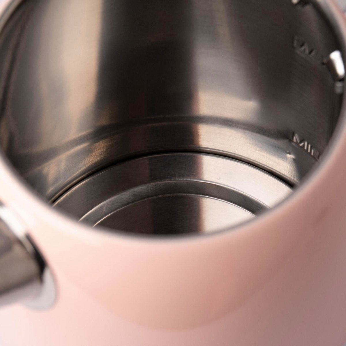 Innenansicht eines rosa elektrischen Wasserkochers. Der Innenraum ist aus Edelstahl, mit Wasserstandmarkierungen. Der Körper ist hellrosa.