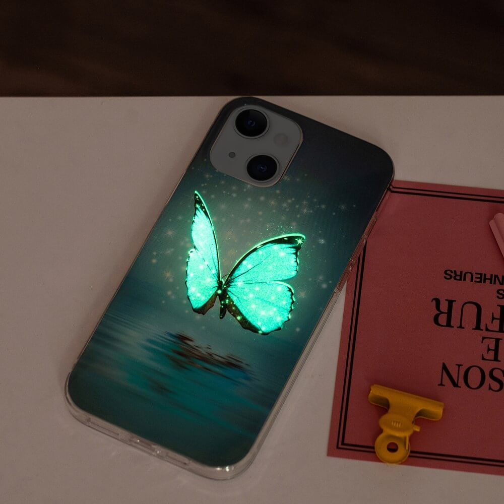Un iPhone avec une coque papillon lumineuse. Le papillon est turquoise. Une carte rose et un clip jaune sont à côté du téléphone.