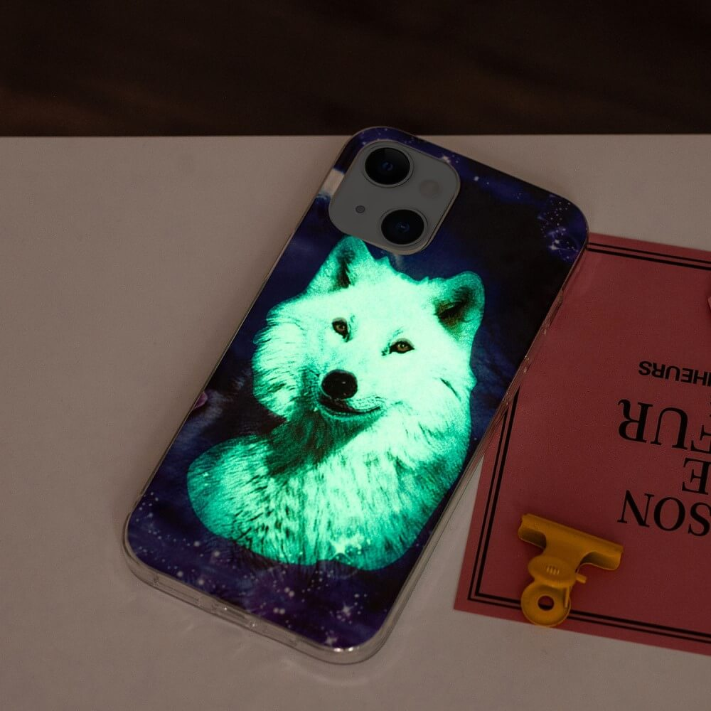 Une coque de téléphone avec un design de loup lumineux. Elle est posée sur une table avec une carte rose et une pince jaune.