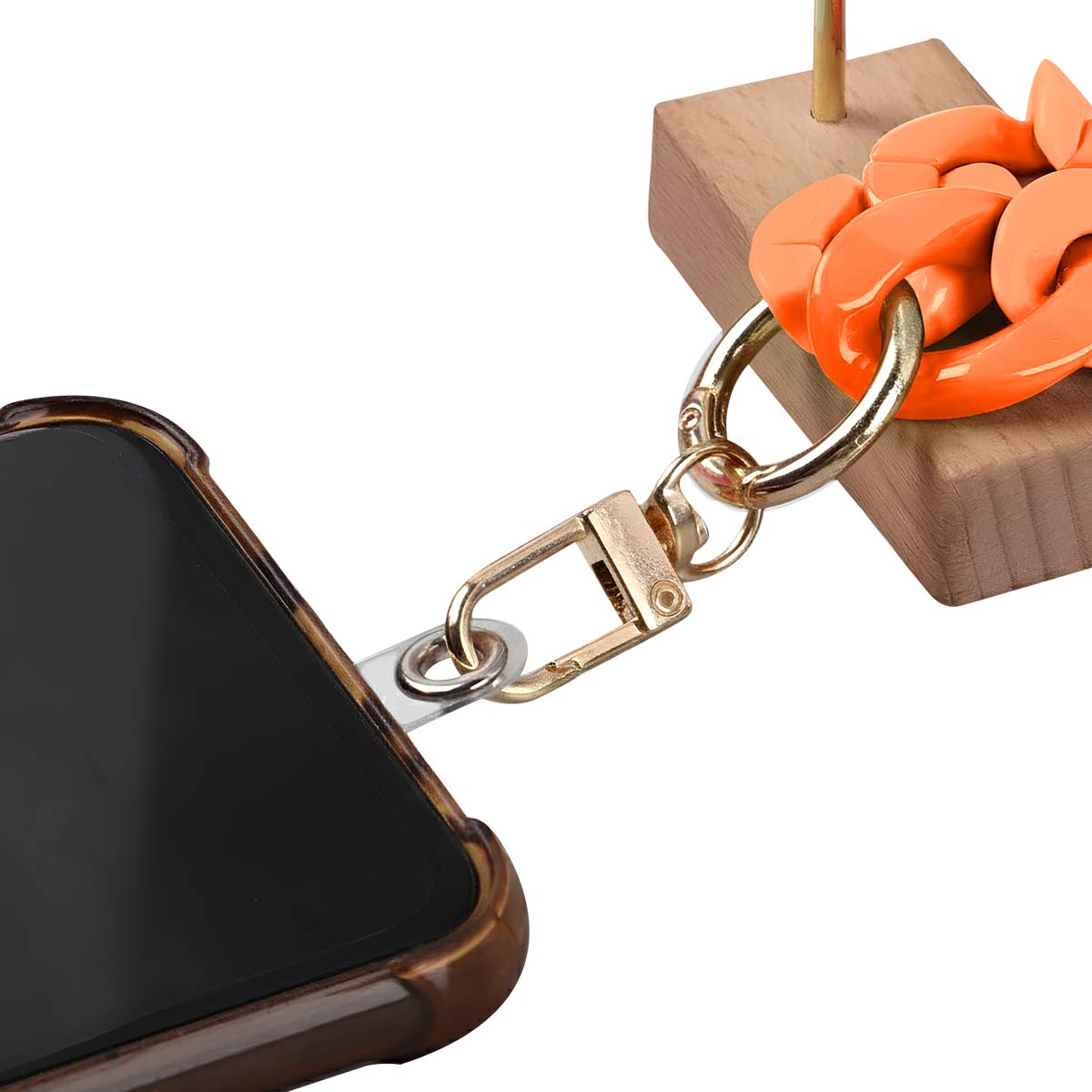 Ein Handycase ist über einen goldenen Verschluss mit einer orangefarbenen Kette verbunden. Die Kette ist an einem Holzblock befestigt.